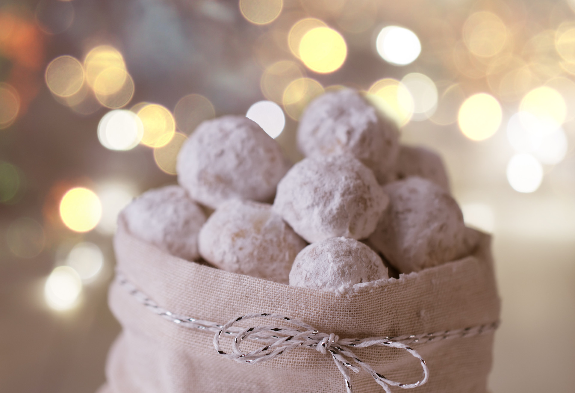 Traditional Christmas cookies with almonds snowball on white background with fairy lights; Shutterstock ID 1229266489; Purpose: Virtual Christmas Guides; Brand (KAYAK, Momondo, Any): Kayak; Client/Licensee: KAYAK