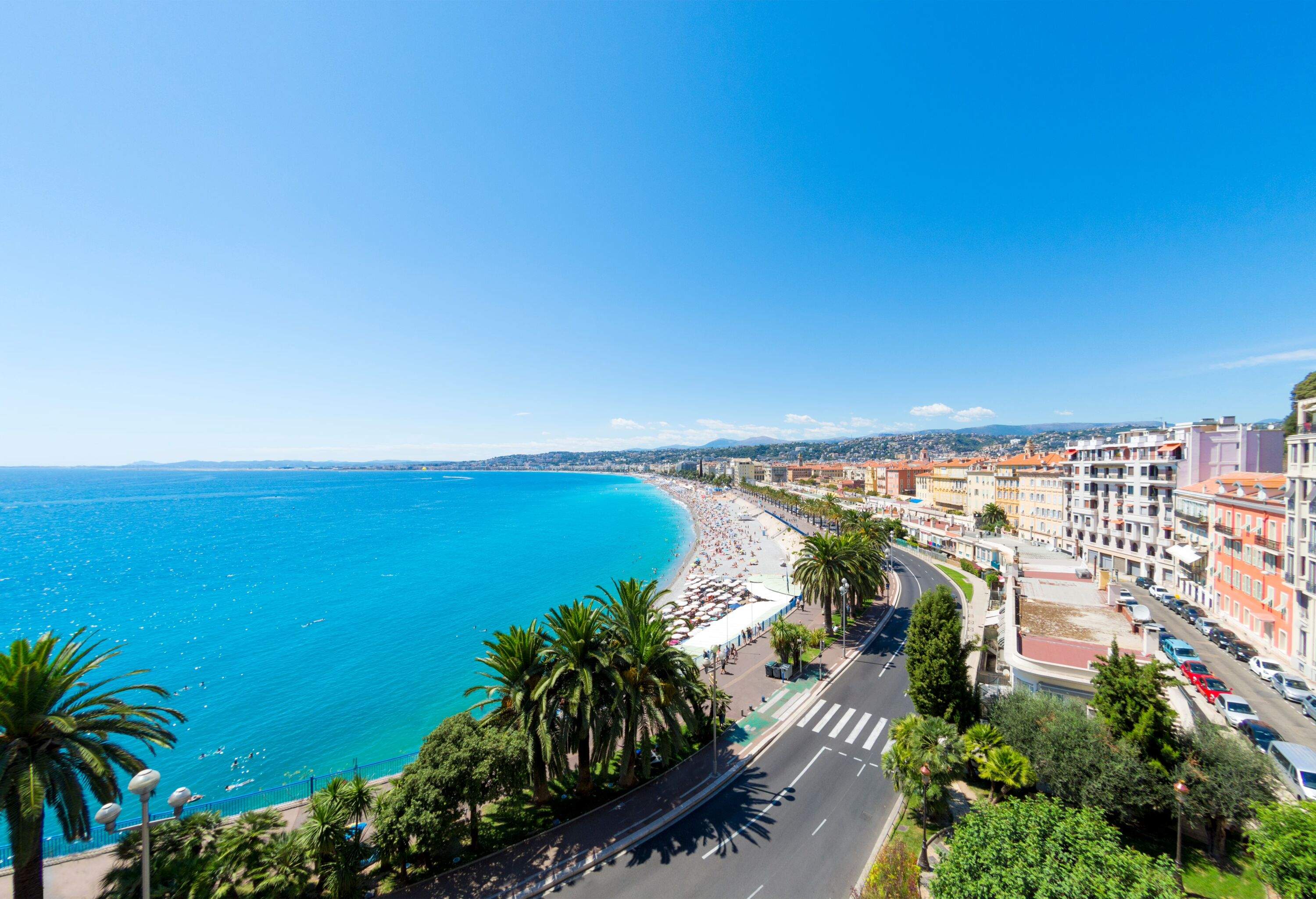 A view along the Promenade des Anglais and beach and seafront in Nice, France. Logos removed.