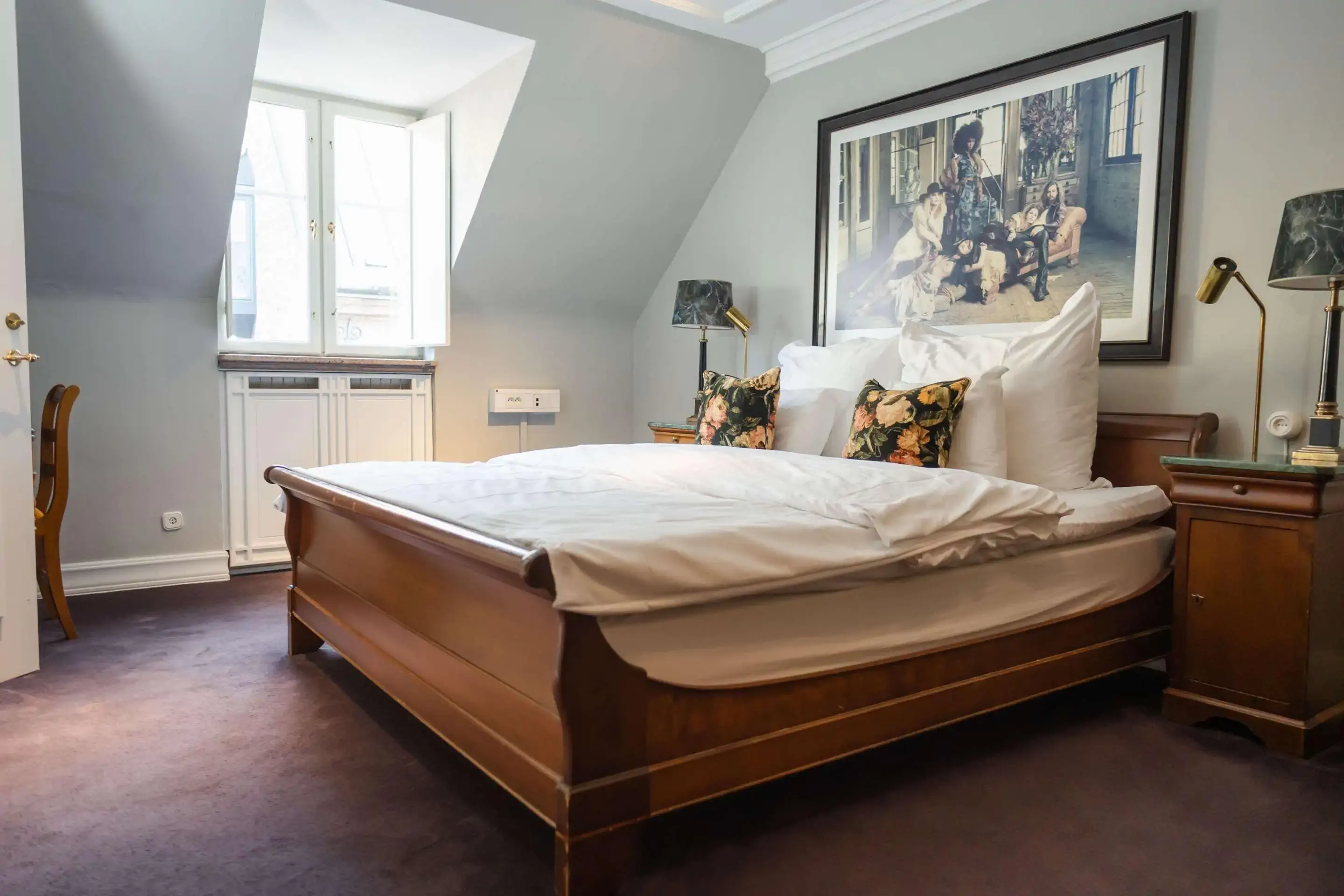 a hotel room with a wooden bed and flower pillows