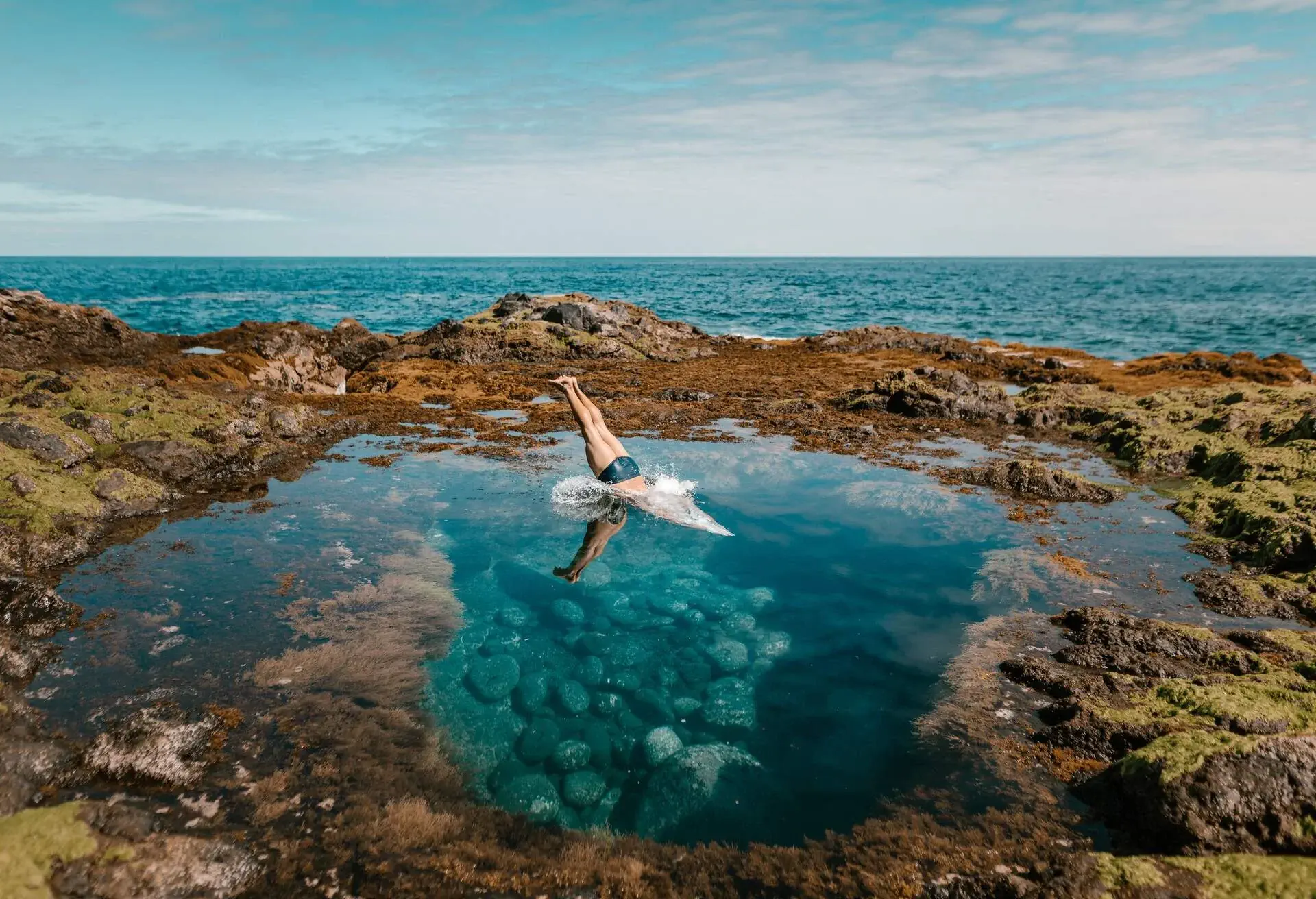 Man diving in rock pool in the Canary Islands