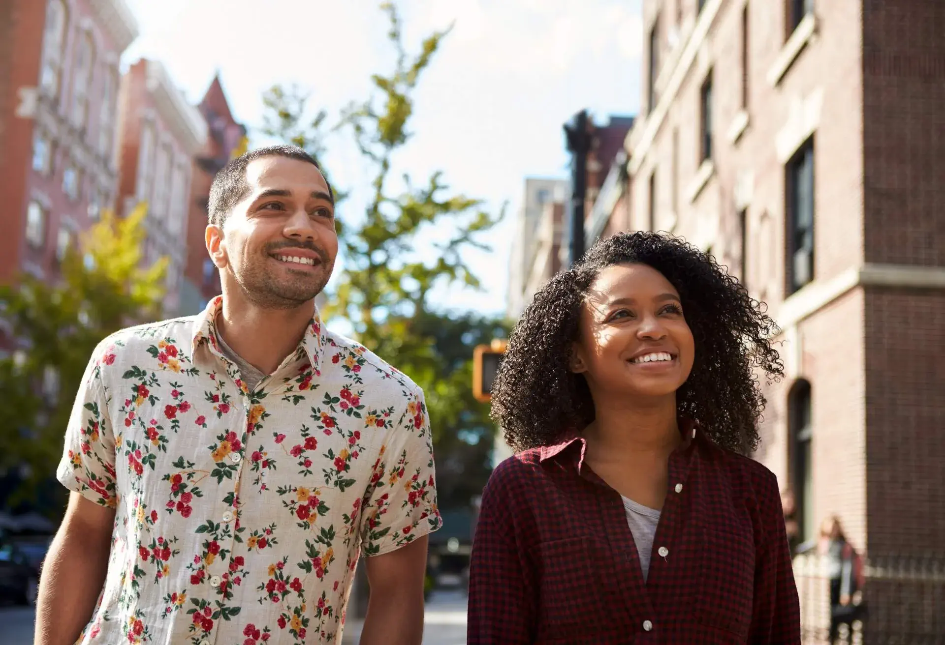 A couple looks up as they walk on the street.