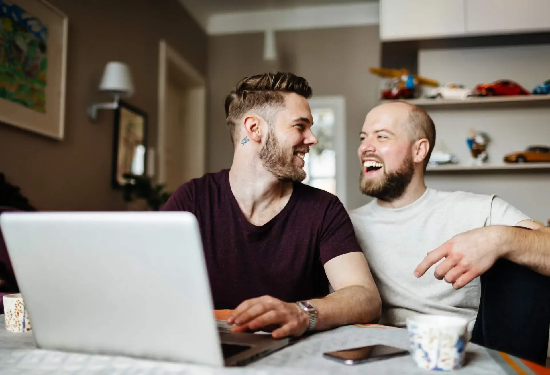 LGBTQ couple looking at computer laughing
