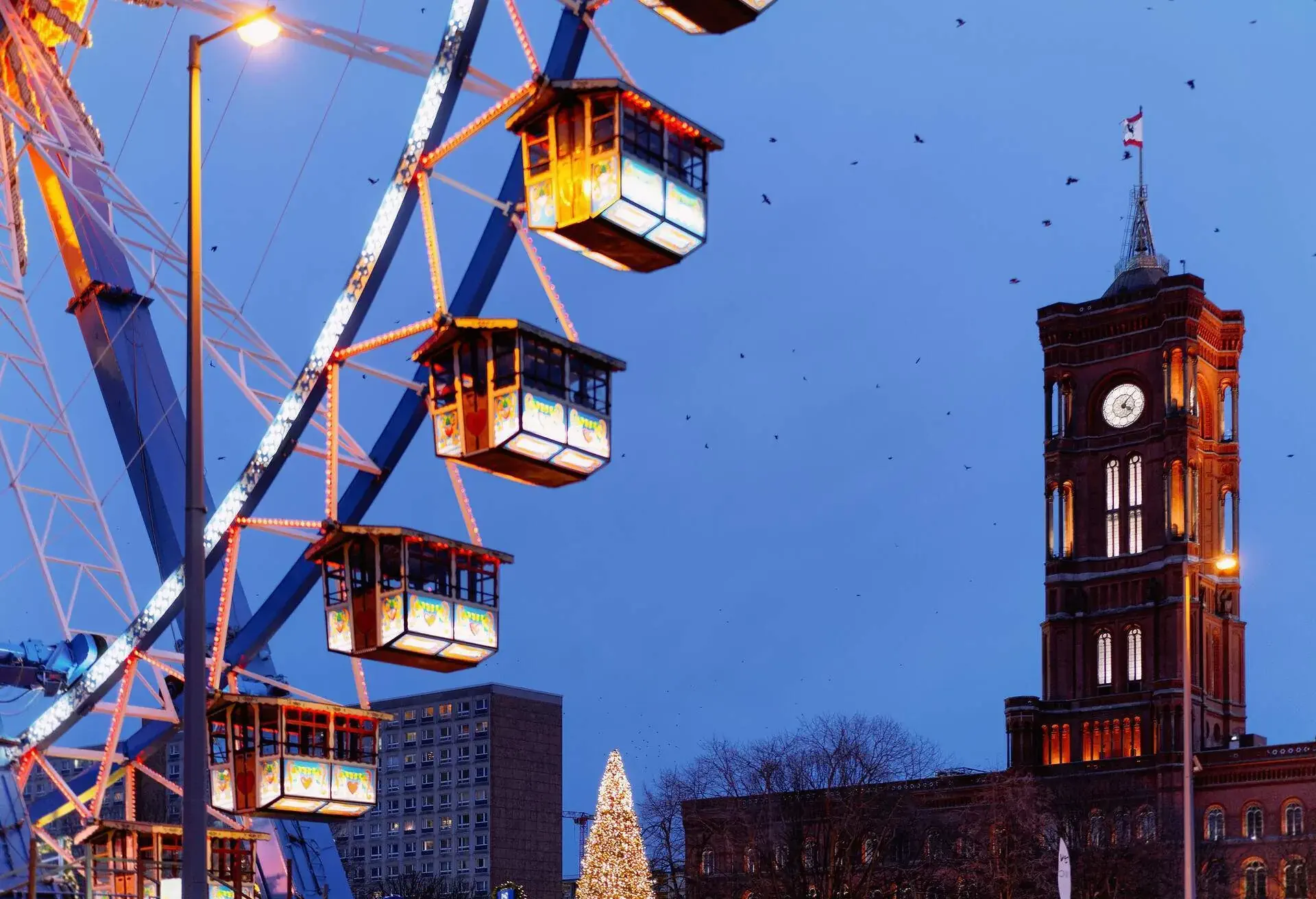 Ferris Wheel and Town Hall at Night Christmas Market in Winter Berlin, Germany.