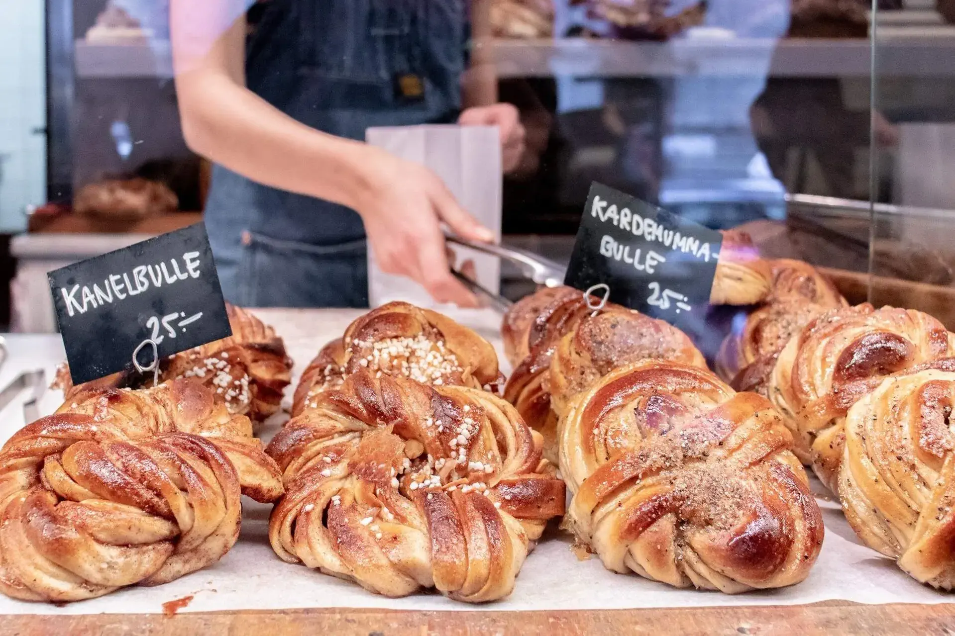 A display of baked cinnamon rolls with labels and pricing.