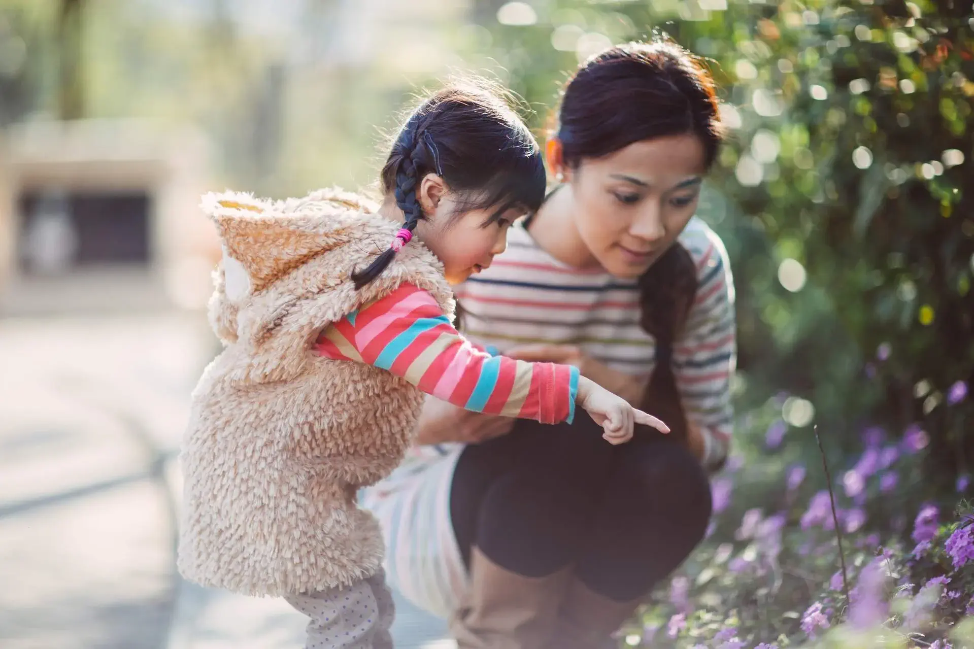 A woman and her daughter looking closely at some plants