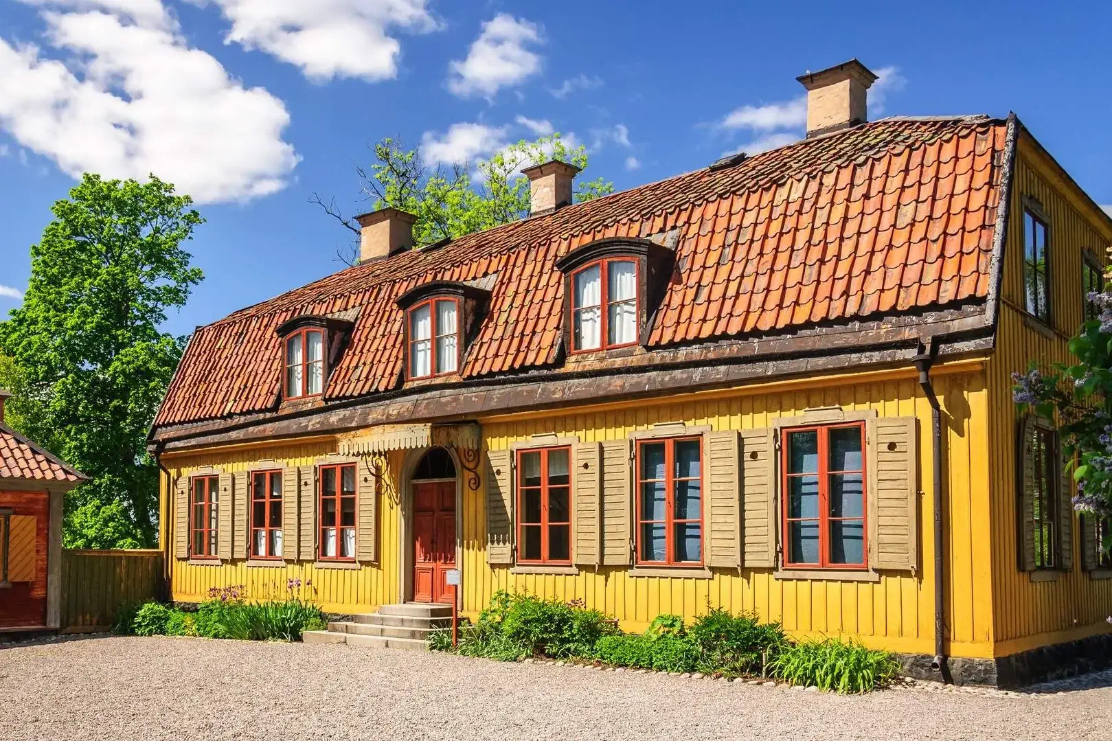 Colourful wooden cottages with tiled roofs set against a beautiful morning sky.
