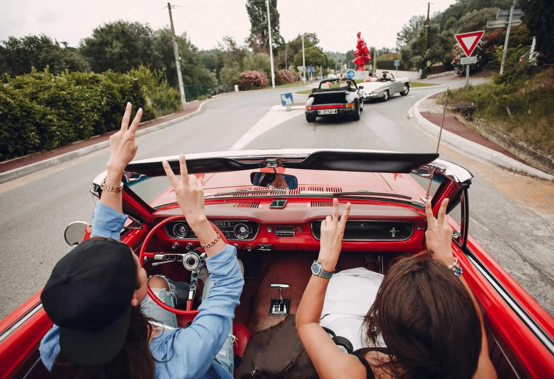 People driving a red cabriolet car in the south of France