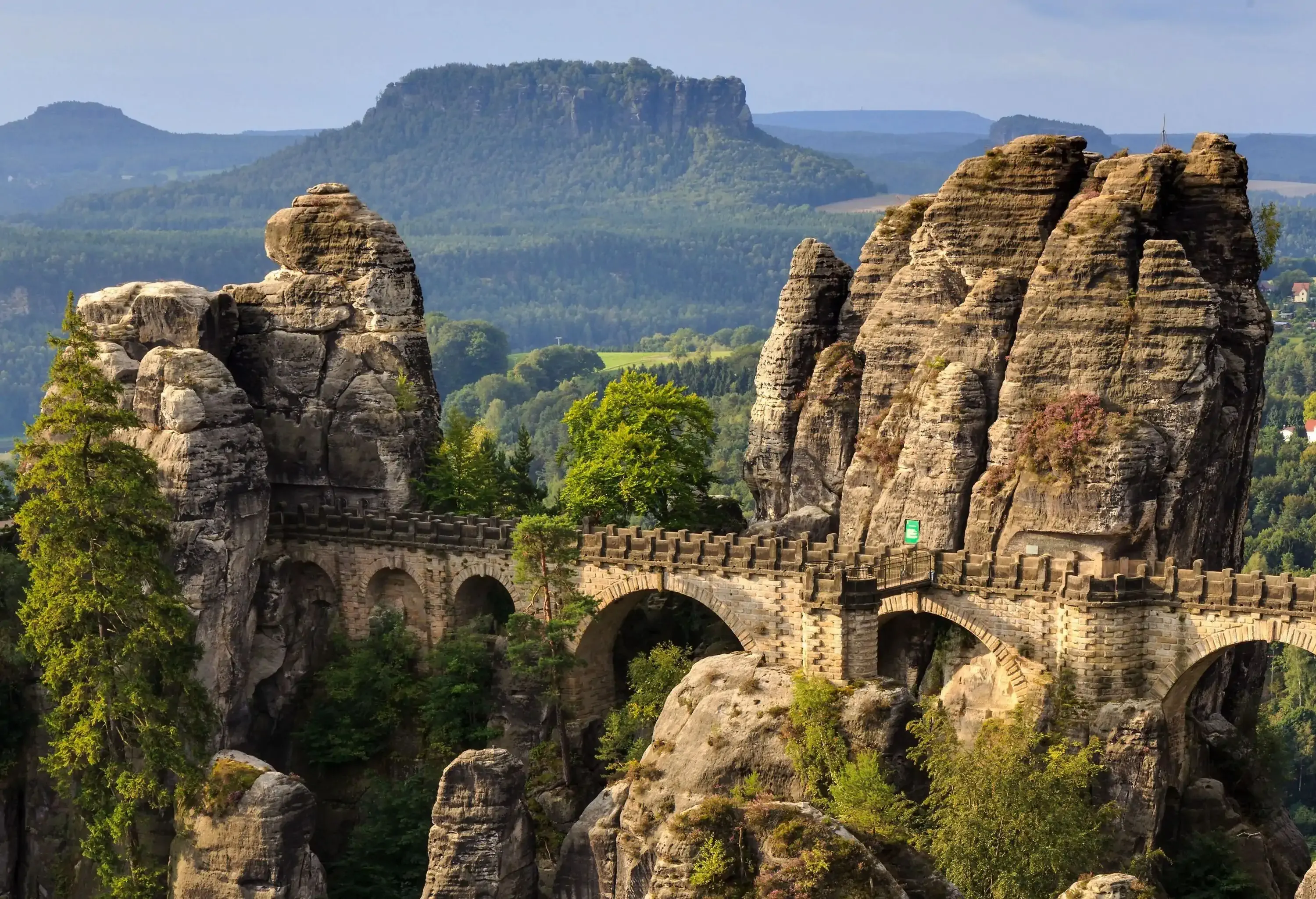 A picturesque scenery of natural and gigantic pinnacles of rock towers with a spanning stone footbridge.
