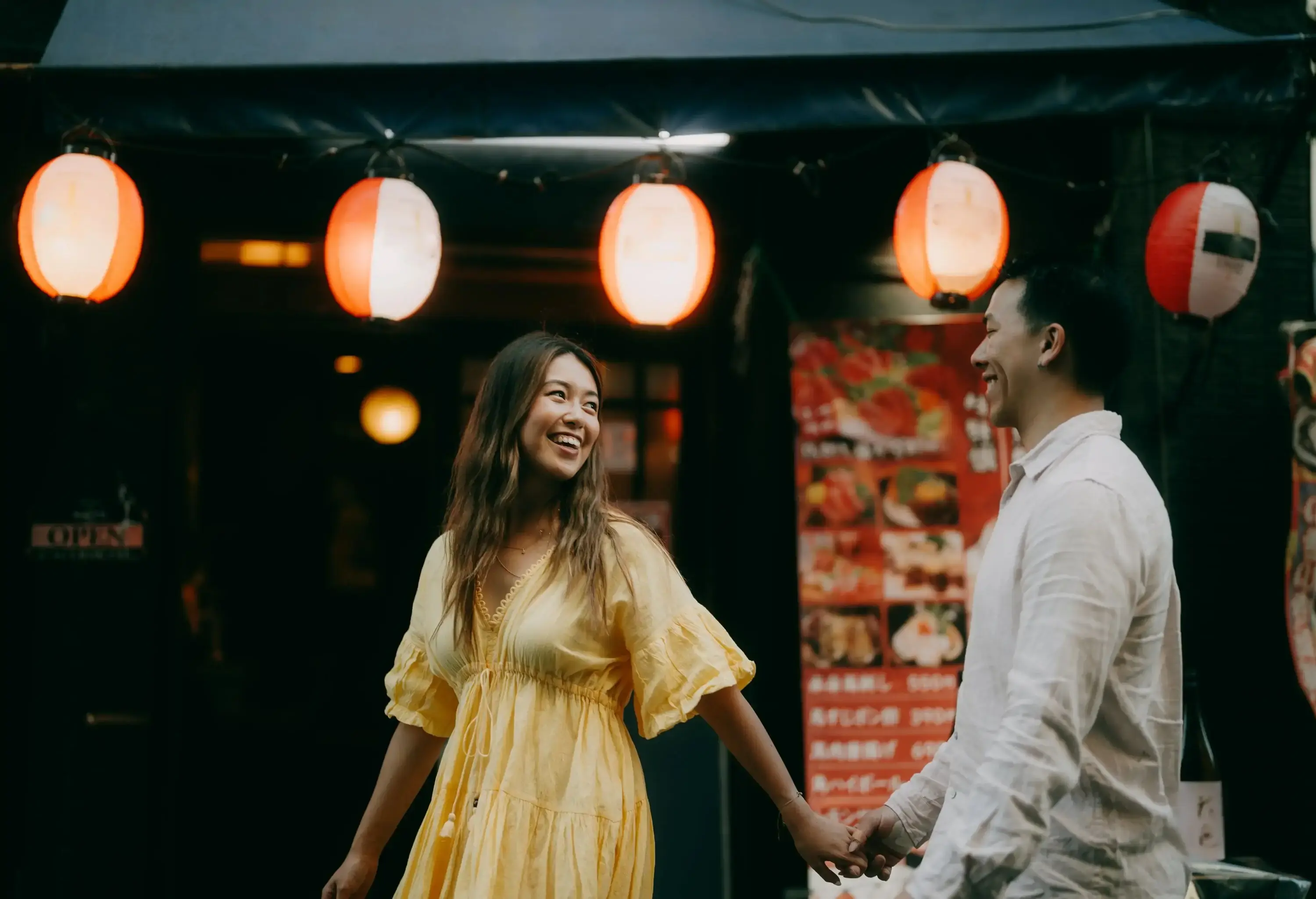 Couple having a good time in Tokyo backstreet with izakaya