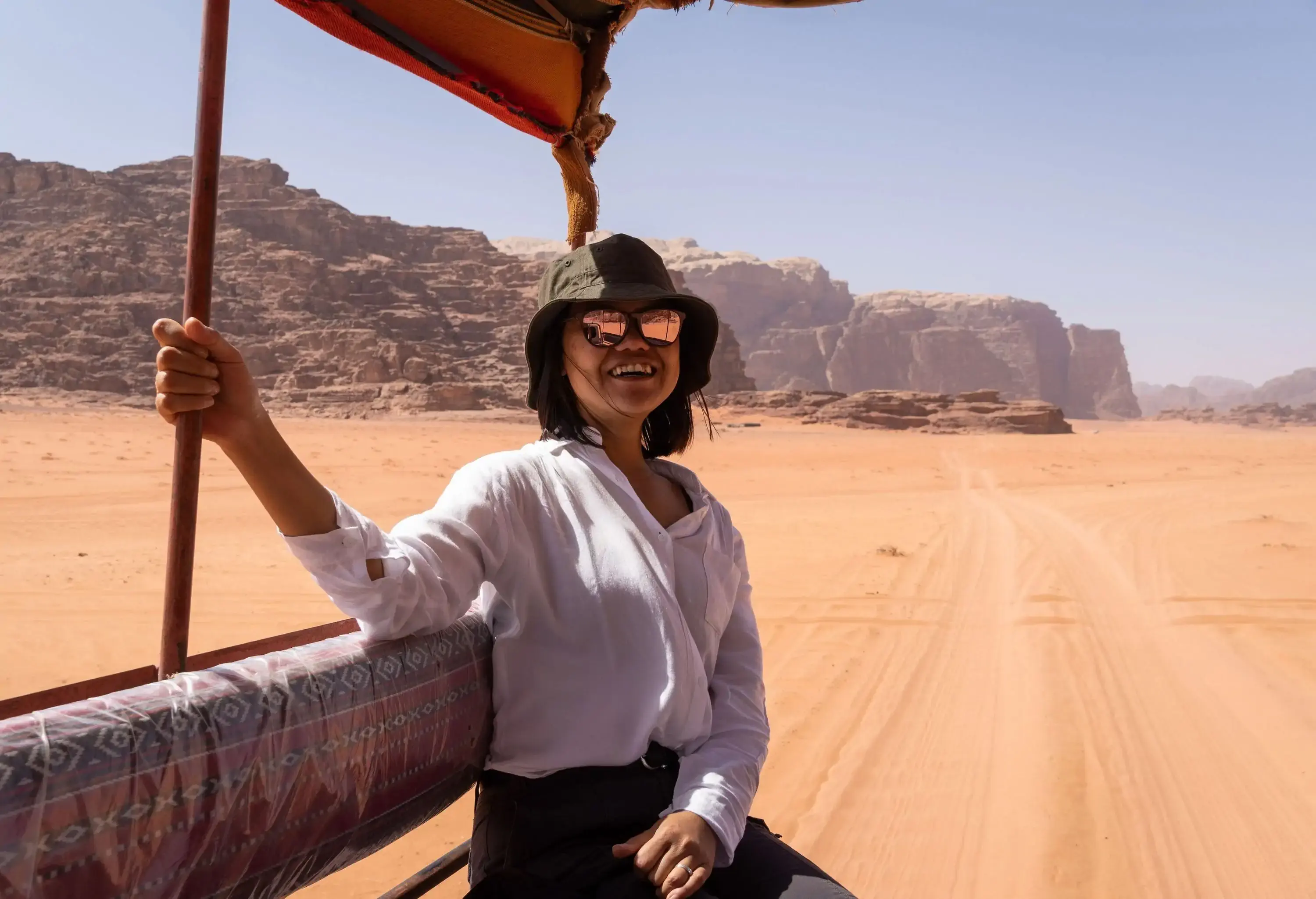 Young Asian female tourist riding a jeep in Wadi Rum desert in Jordan