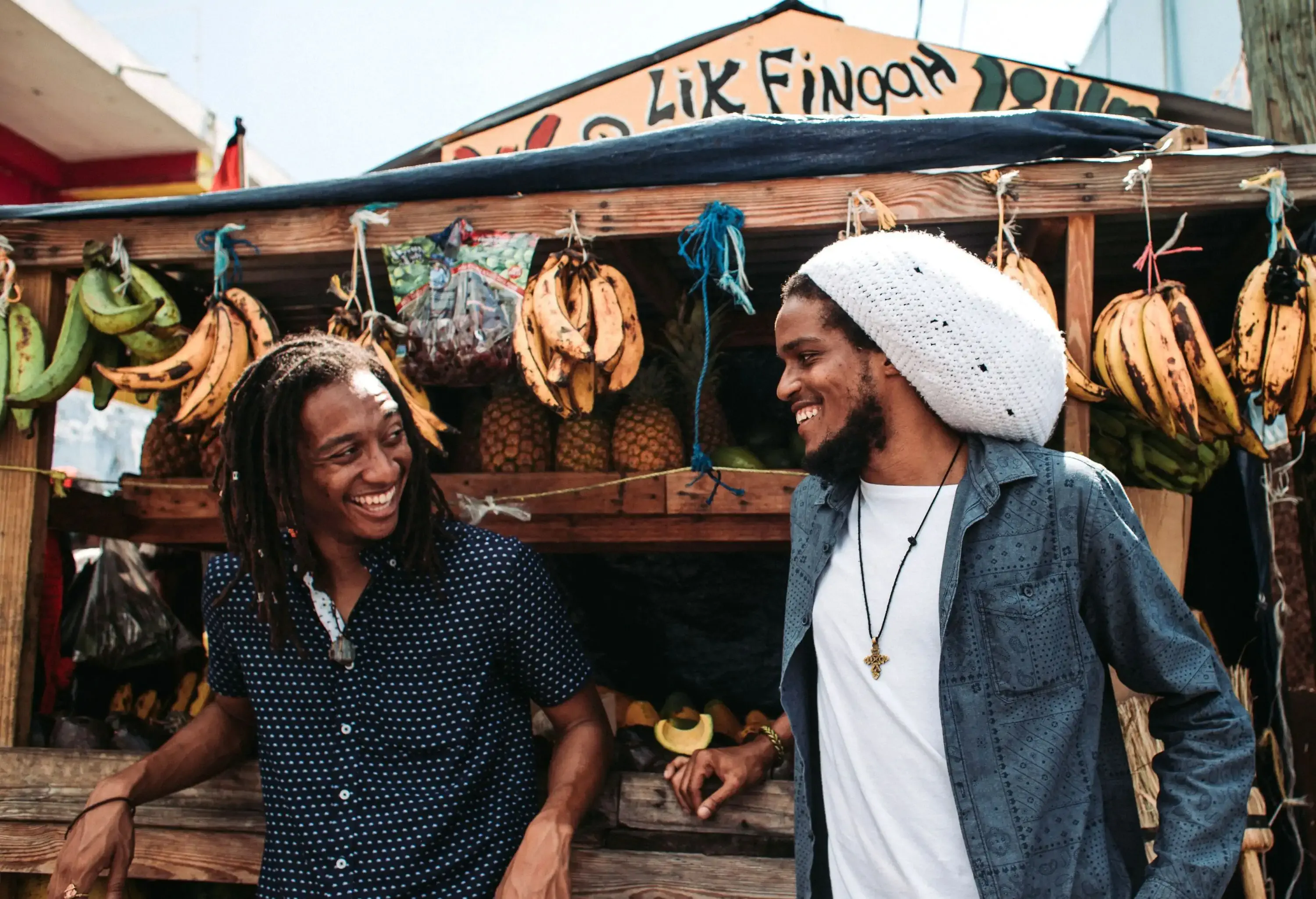Two Rastaman laughing with Fruits at a stall in Jamaica city