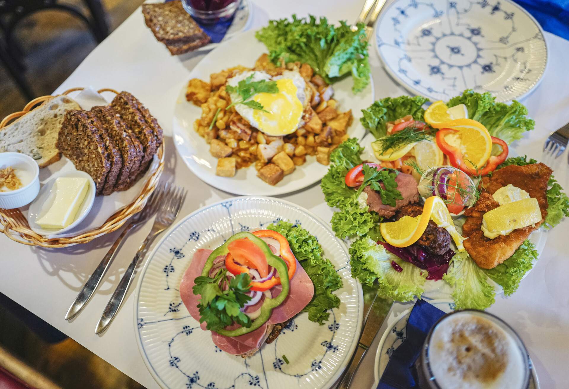 The famous Danish Smorrebrod (Smørrebrød) or open sandwiches made with dark rye breads plus various cold toppings and salads, along with traditional Biksemad of fried meat, potatoes, onions and eggs in Copenhagen, Denmark.