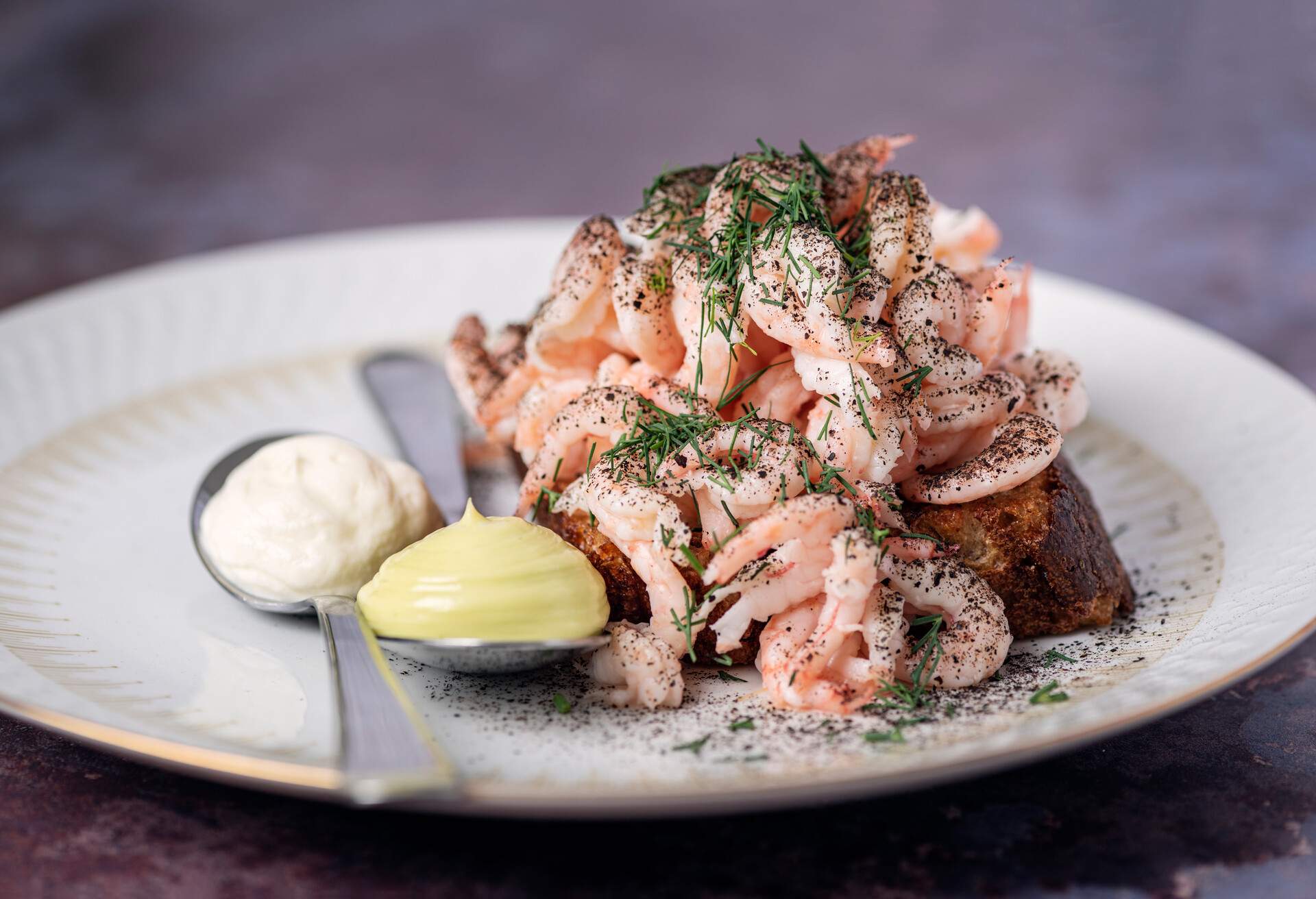 Danish delicacy of shrimps with dill mayonnaise and a danish version of greek yoghurt  or “drained yoghurt. The shrimp is served with lots of fresh dill and chives. Colour, horizontal format with some copy space.