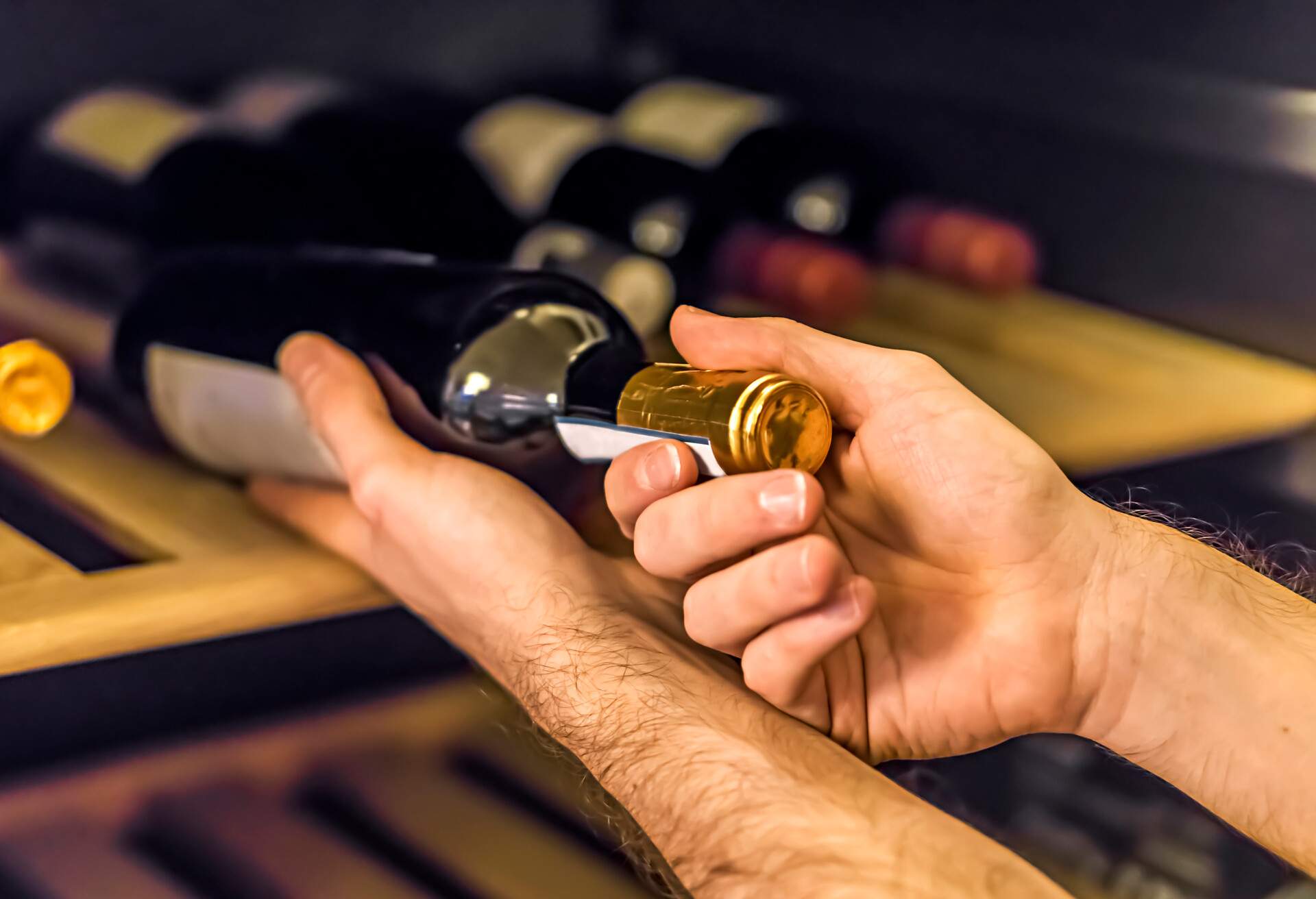 A waiter controls bottles in the wine cabinet 
