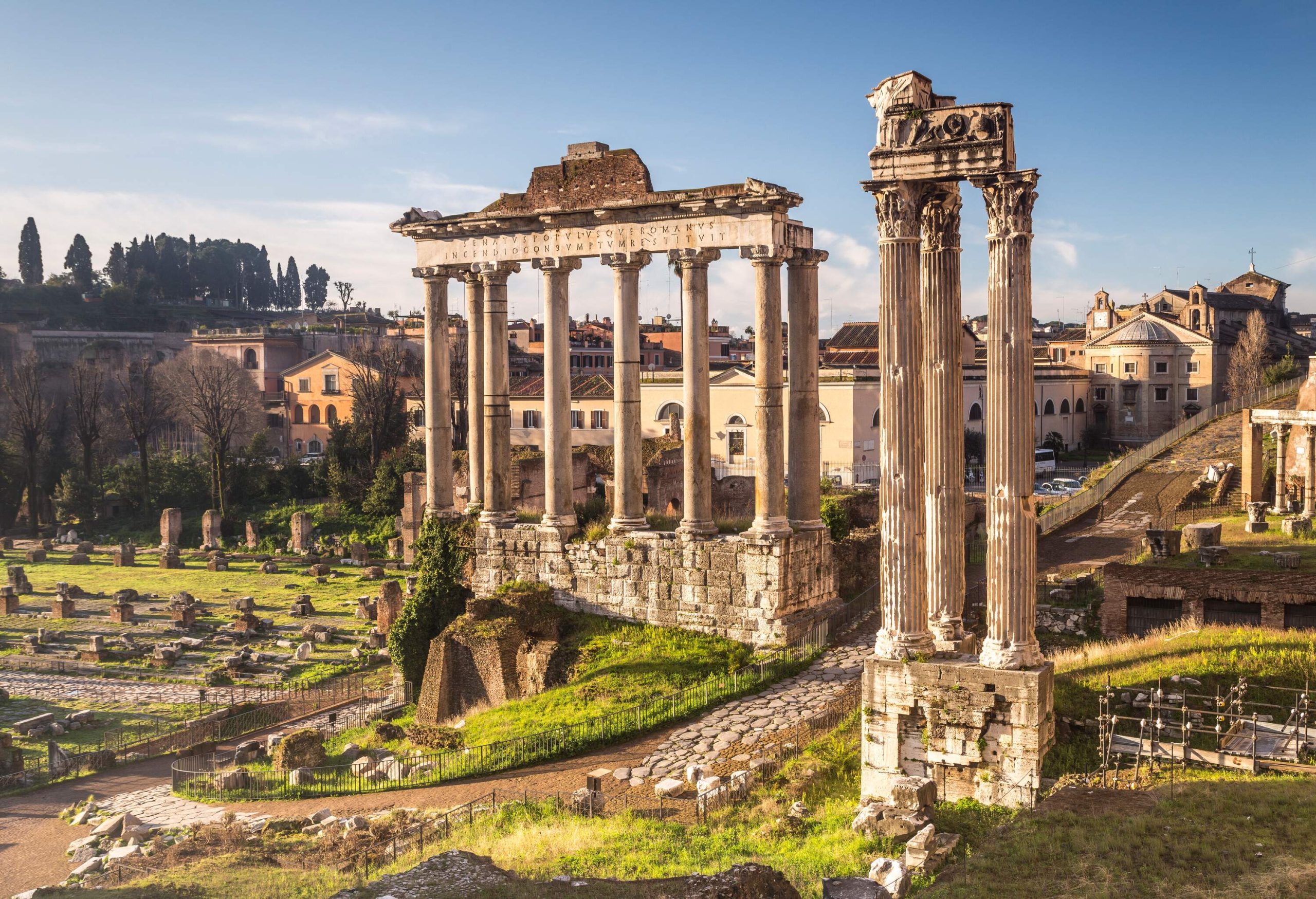 The Roman Forum contains the ruins of some important ancient structures surrounded by a thick cluster of compact buildings.