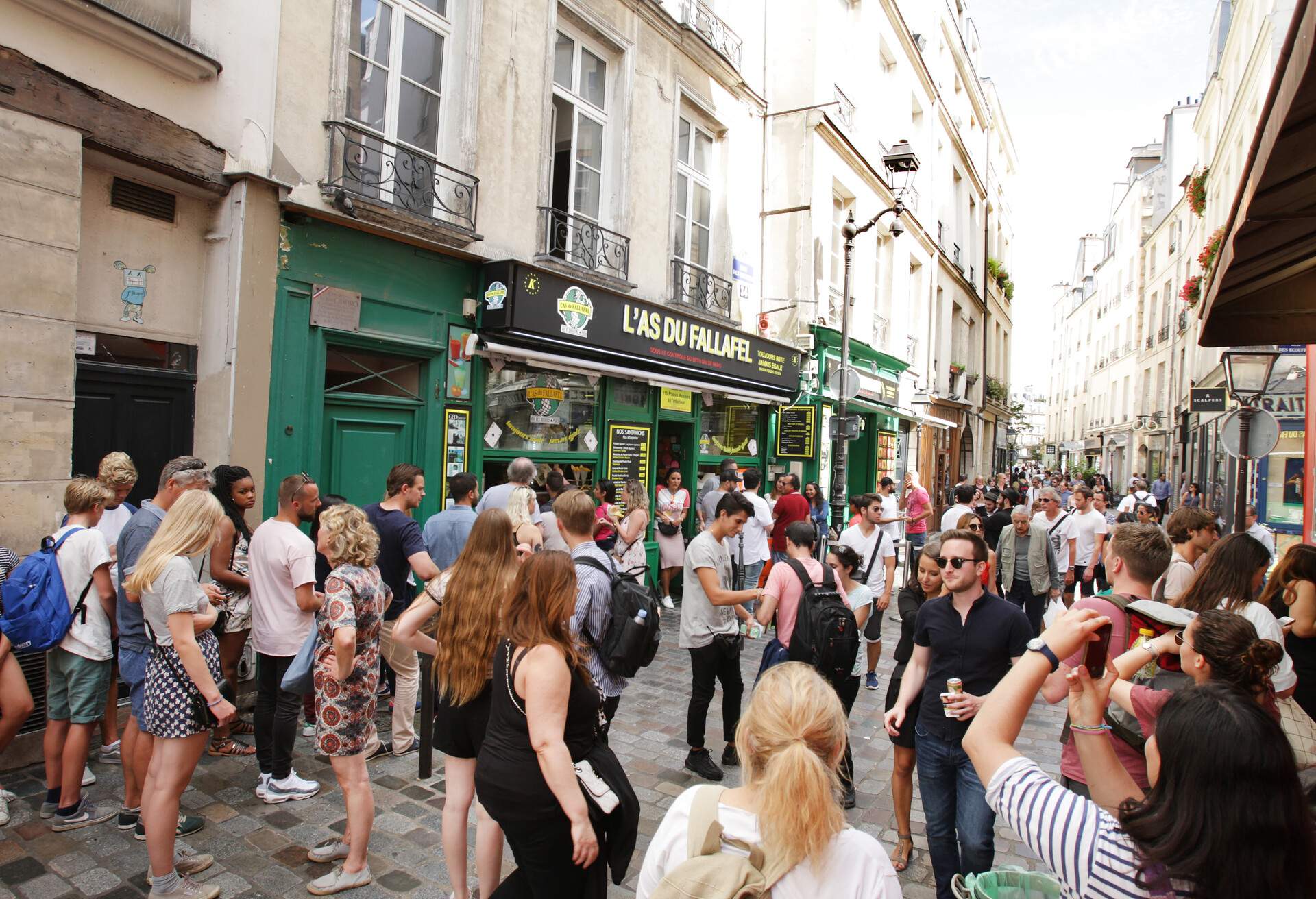 Paris,France - August 14: Tourists enjoying on the rue de Rosiers street in Le Marais district of Paris. The Le Marais district is one of Paris' main Jewish communities.