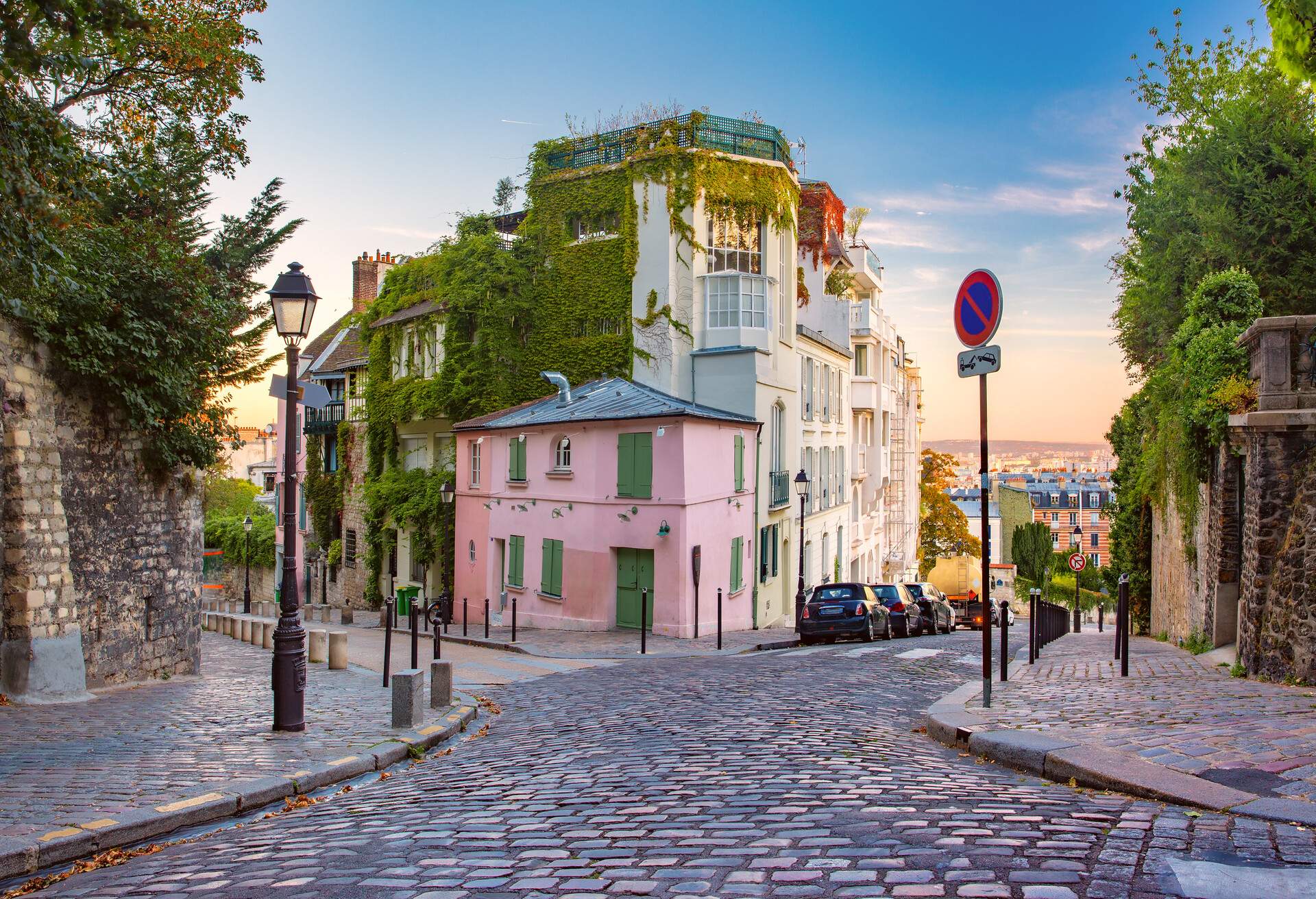 Cozy old street with pink house at the sunny sunrise, quarter Montmartre in Paris, France