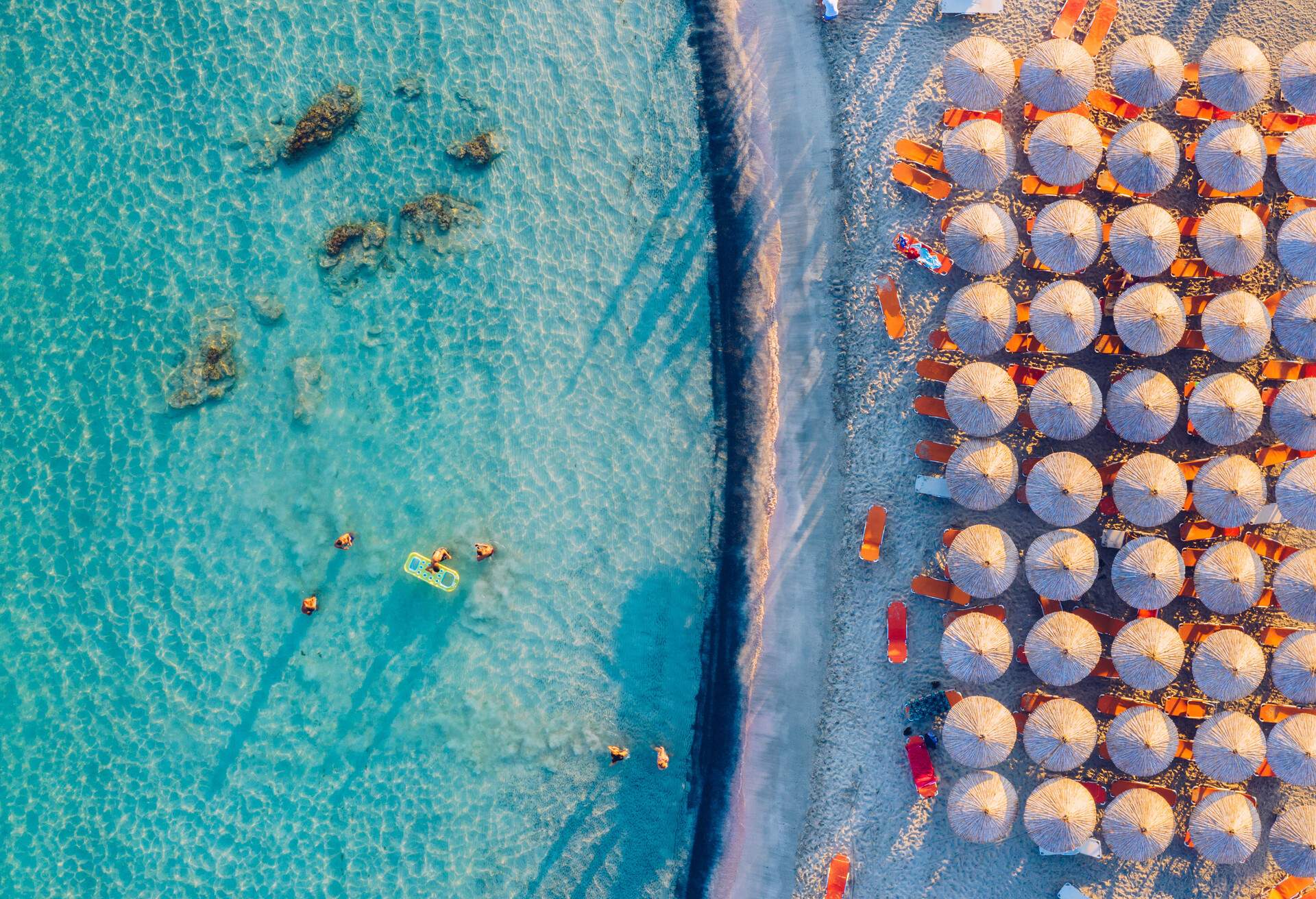 Aerial view of beautiful tropical Elafonissi Beach with pink sand. View of a nice tropical beach from the air. Beautiful sky, sea, resort. Seascape: Ocean and beautiful beach paradise. Elafonissi beach, Crete, Greece.