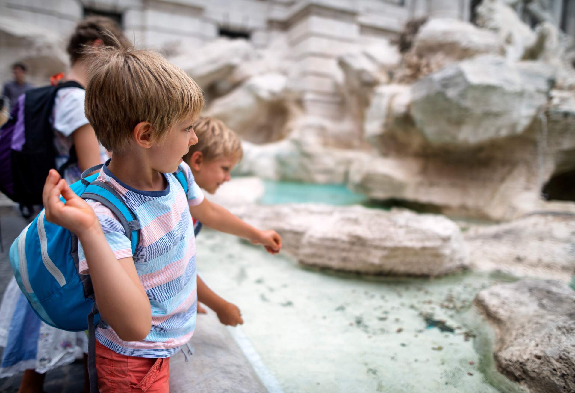 Kids sightseeing Rome, Italy. They are throwing coins into Trevi Fountain, Rome..Nikon D800