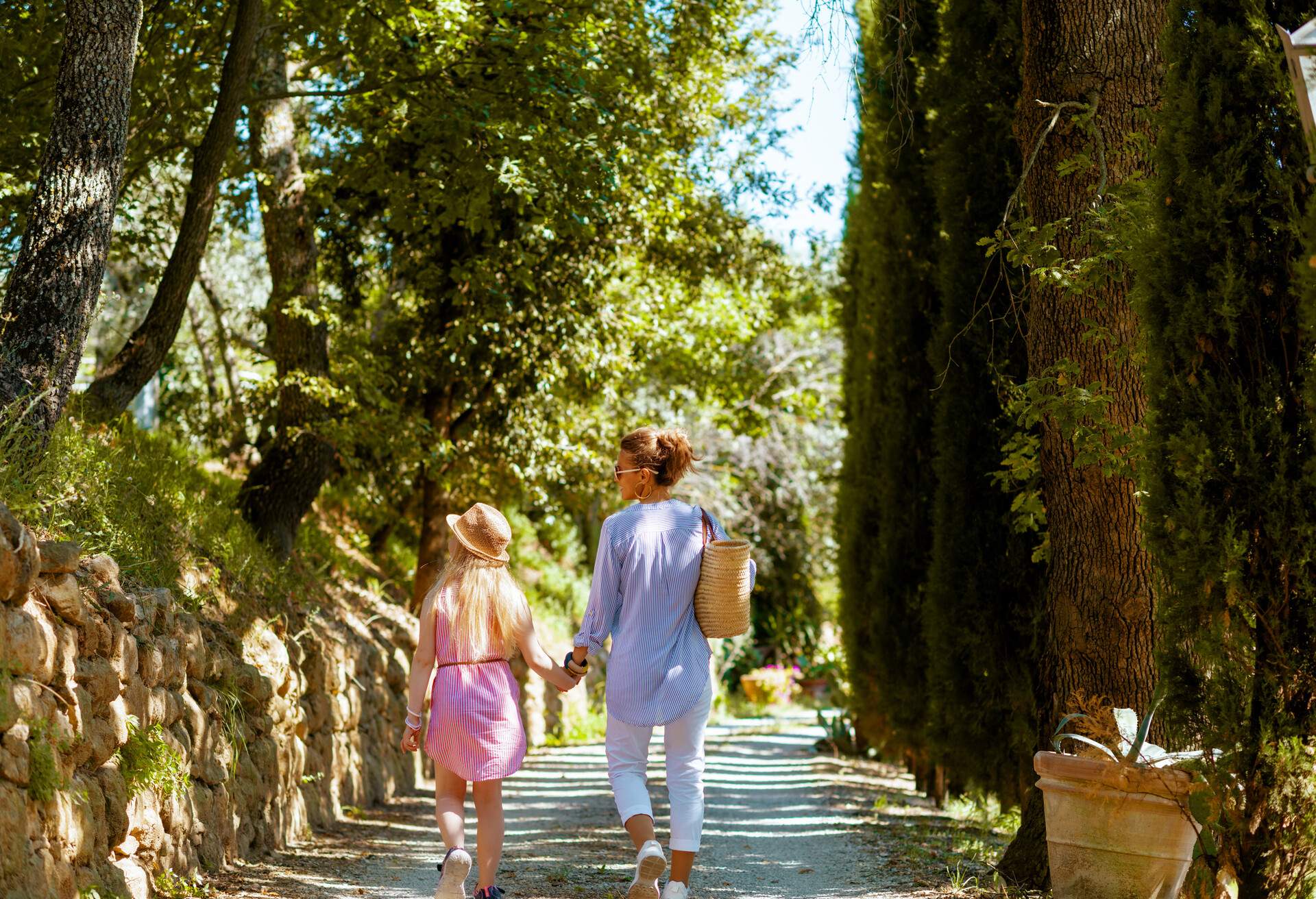 Travel in Italy. Seen from behind trendy mother and daughter in Tuscany, Italy walking.