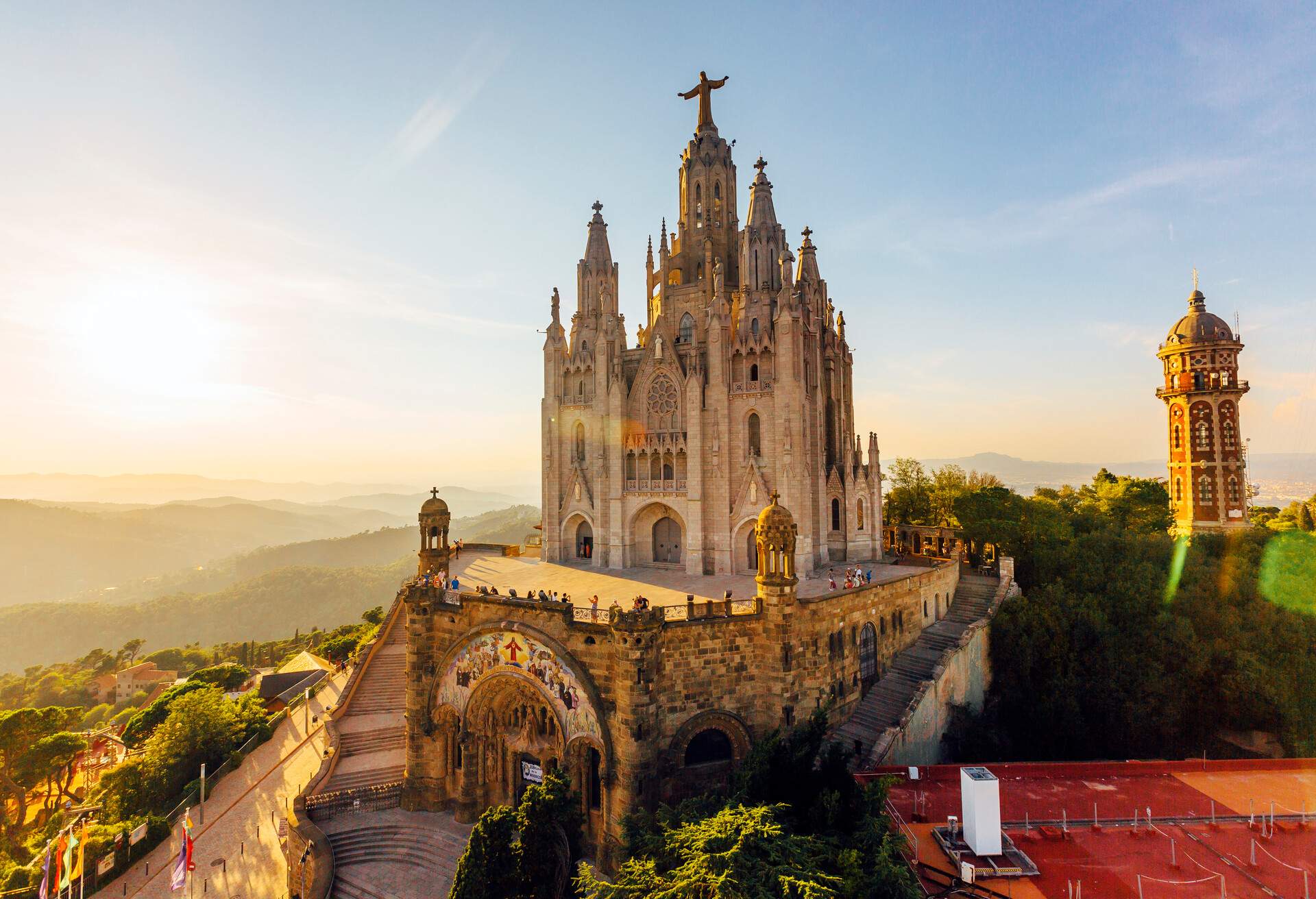 The Romanesque architecture crypt is topped by a palace-like neo-Gothic church of the Expiatory Church of the Sacred Heart of Jesus at the summit of the lush Mount Tibidabo in Barcelona, Spain.