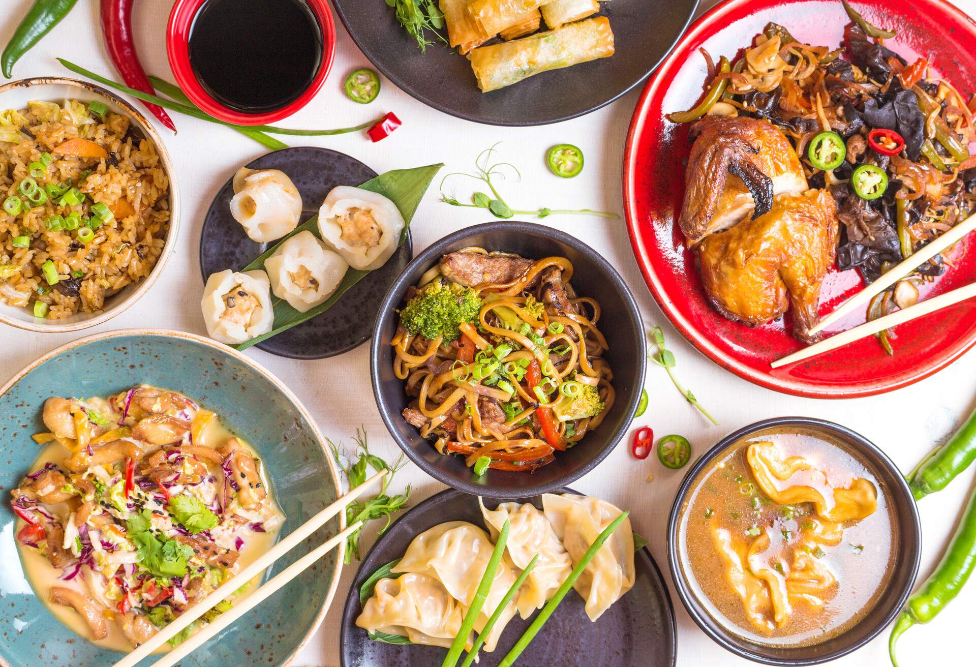 Assorted Chinese food set. Chinese noodles, fried rice, dumplings, peking duck, dim sum, spring rolls. Famous Chinese cuisine dishes on white table. Top view. Chinese restaurant concept. Asian style ; Shutterstock ID 446808112; Purpose: product; Brand (KAYAK, Momondo, Any): any