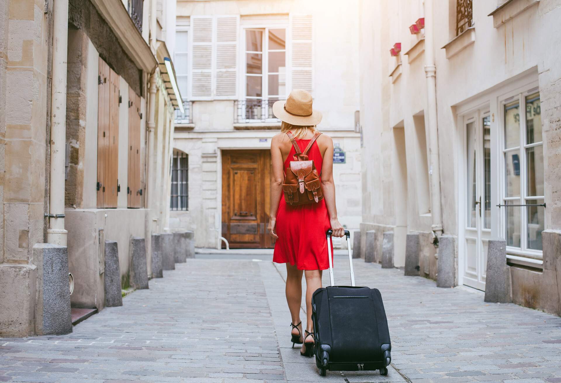 travel background, woman tourist walking with suitcase on the street in european city, tourism in Europe