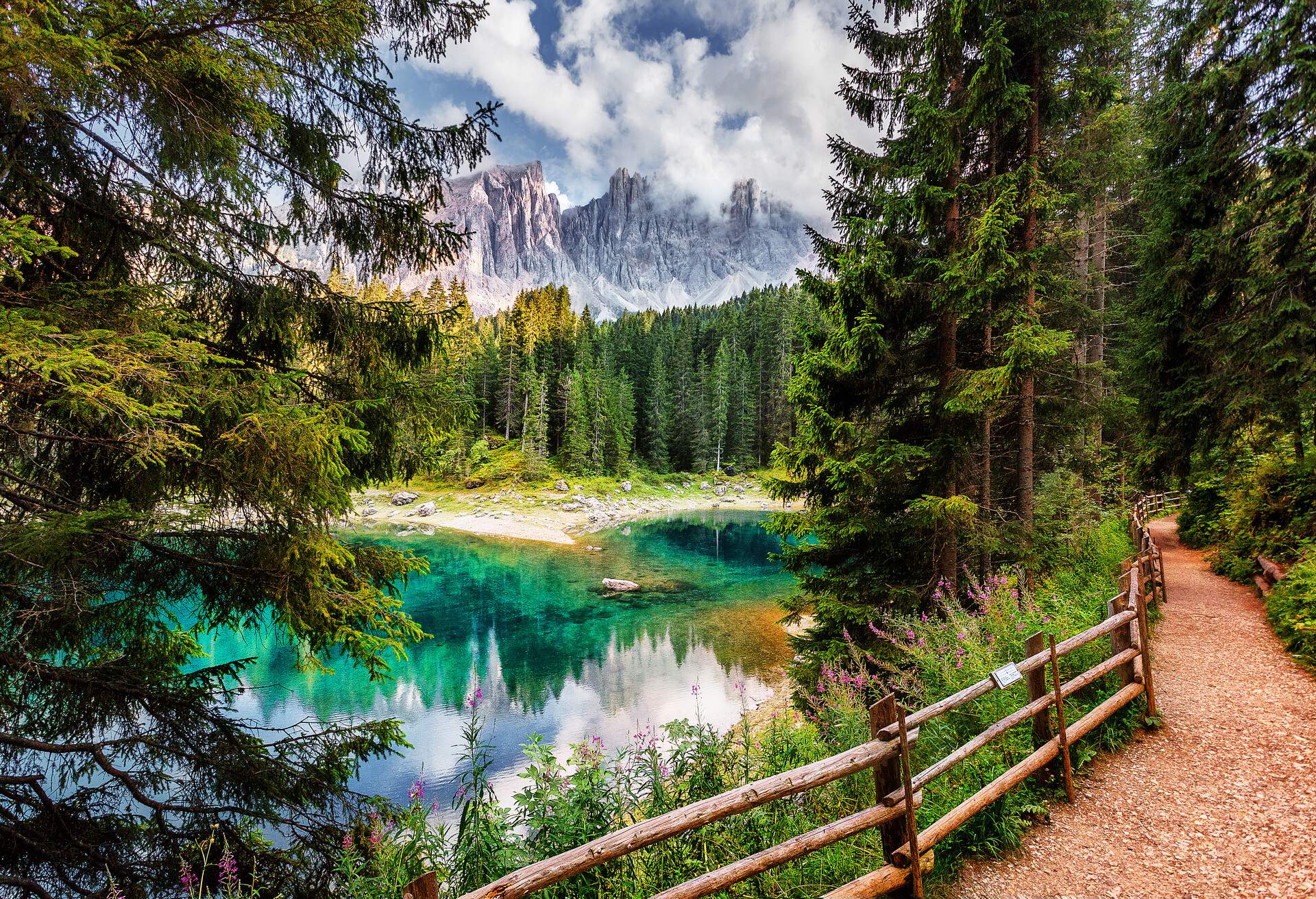Amazing nature landscape. Lago di Carezza lake or The Karersee with reflection of mountains in the dolomite alps, Dolomites, Tyrol, Italy. Concept of ideal resting place. Popular travel destination.