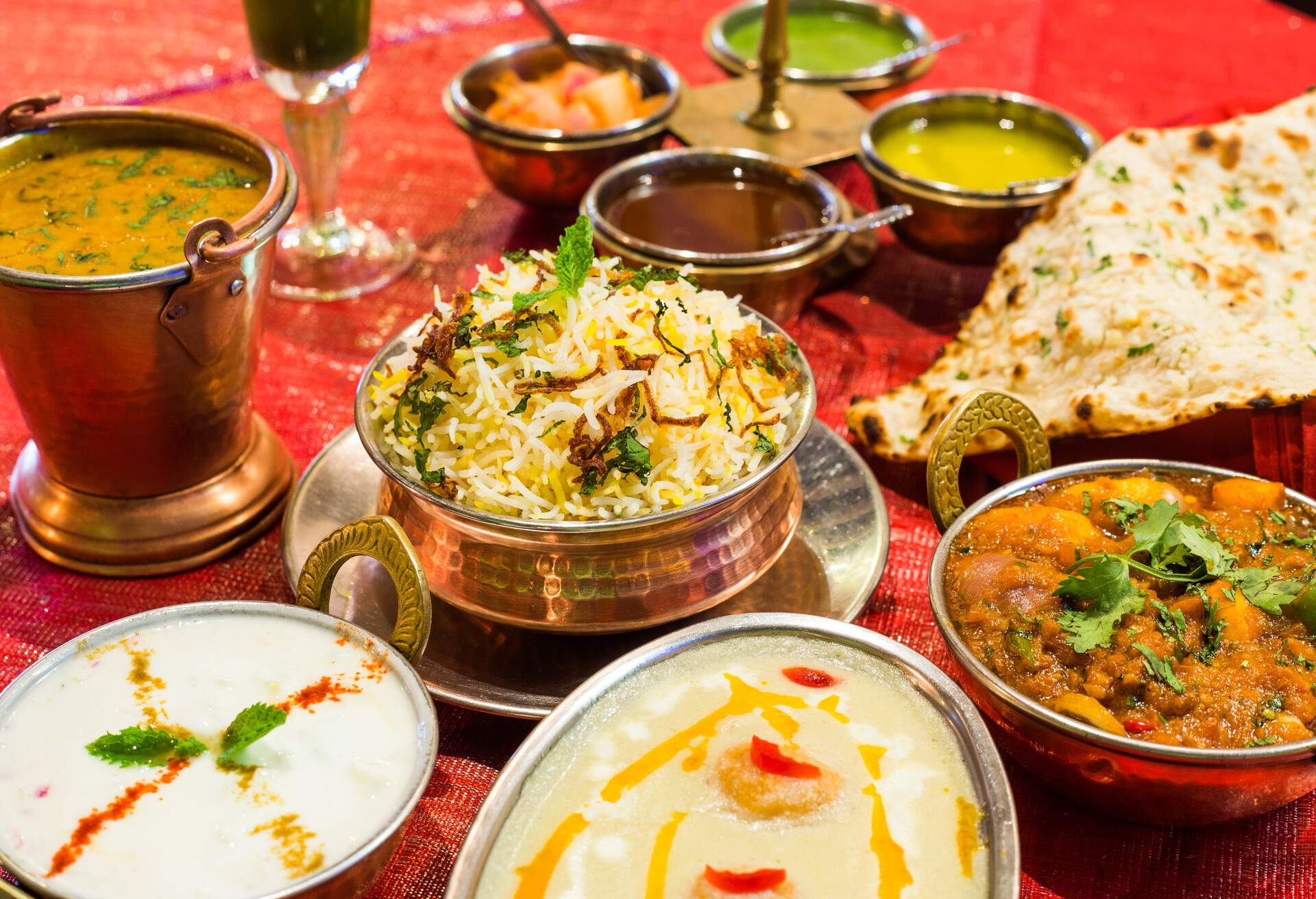 Indian chicken curries with naan bread, rice and pickles.