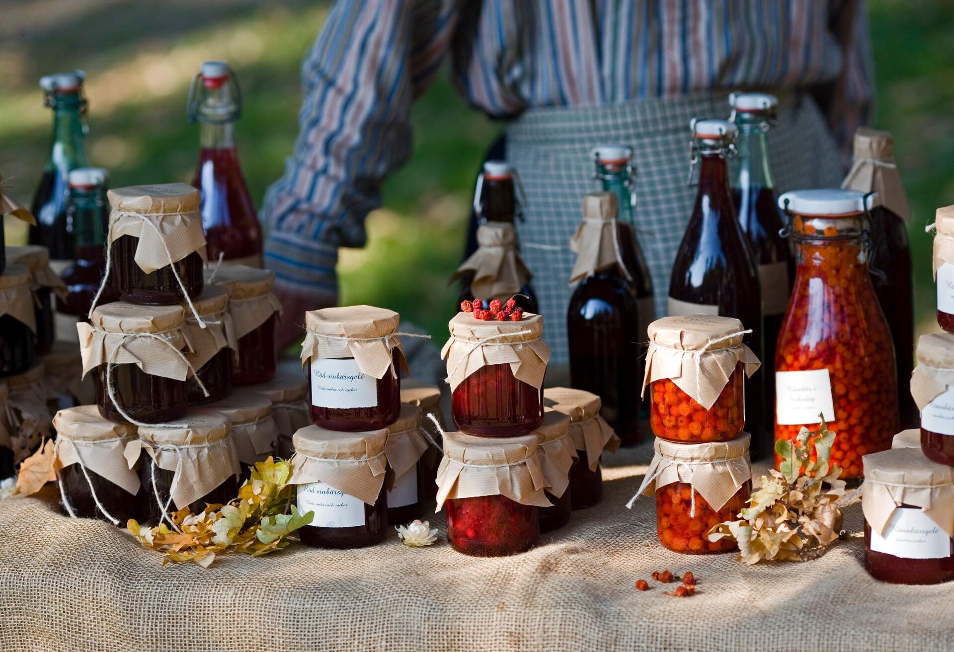 Homemade jars of jam and fruit juices for sale at a farmers' market.