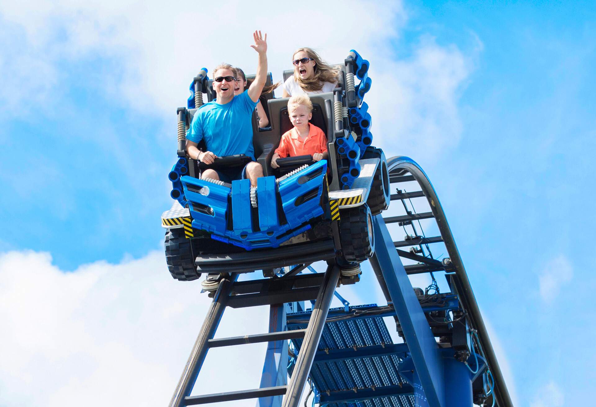 Young family having fun riding a rollercoaster at a theme park. Screaming, laughing and enjoying a fun summer vacation together.; Shutterstock ID 1417019741