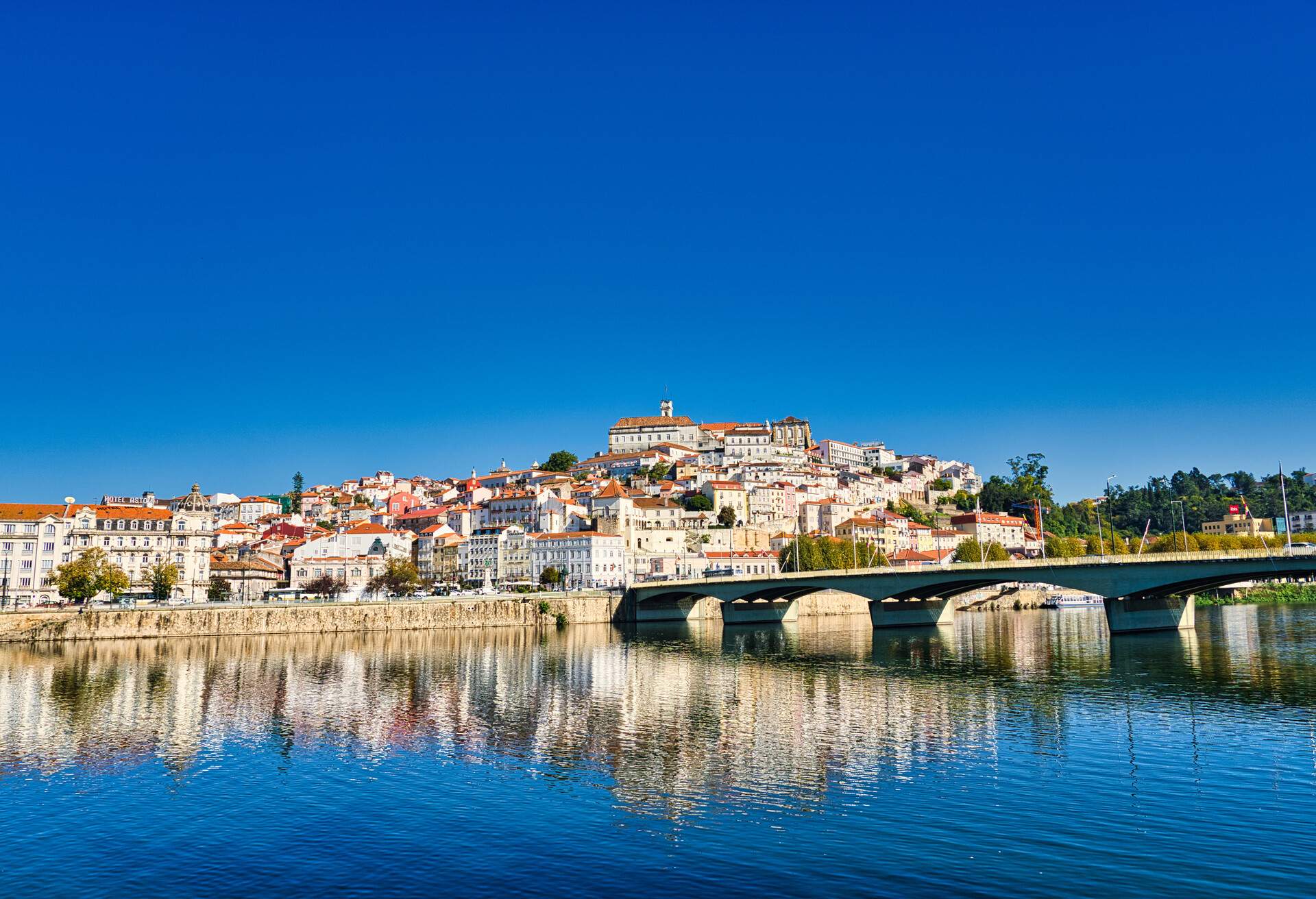 View of the historic center of Coimbra from the Mondego river. The university city of Coimbra is the capital of the Coimbra district and is located on the Rio Mondego, which flows into the Atlantic. Coimbra in October 2020.