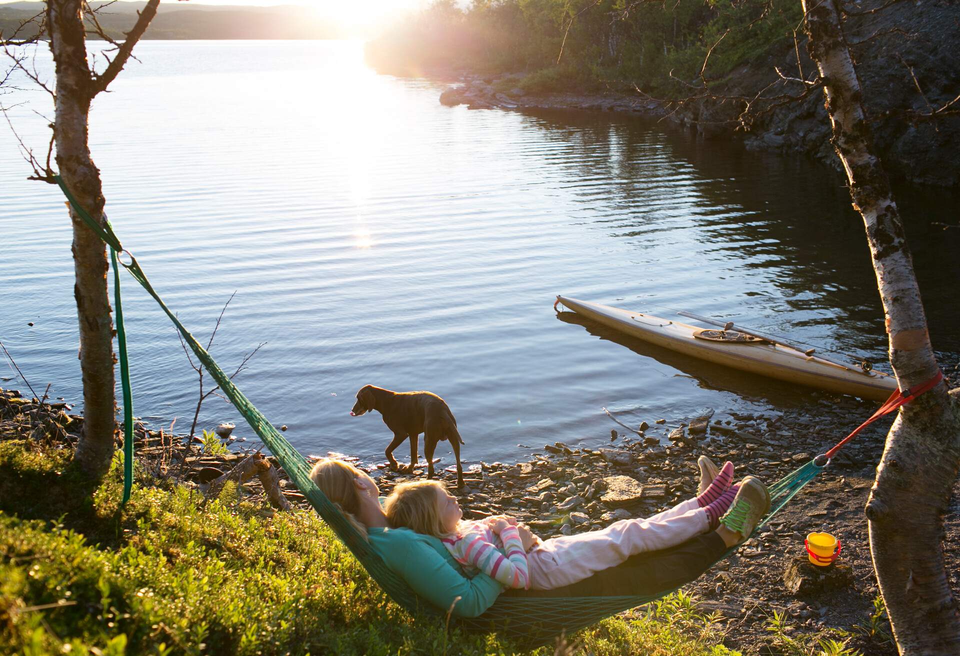 Mother and daughter relaxing in a hammock - lakeside