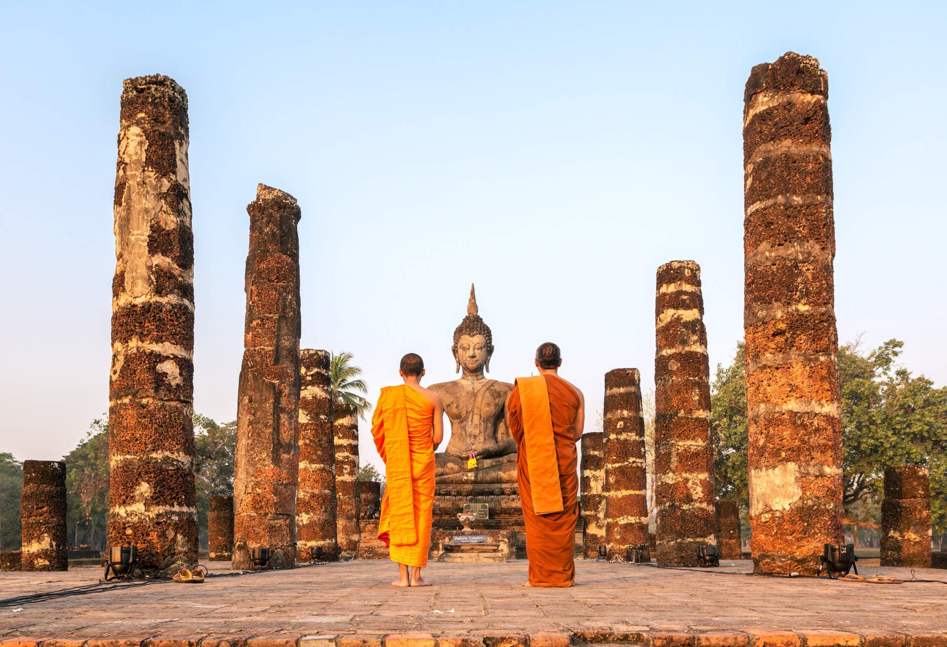 Thailand, Sukhothai Historical Park. Two buddhist  monks at Wat Mahathat temple at sunrise.