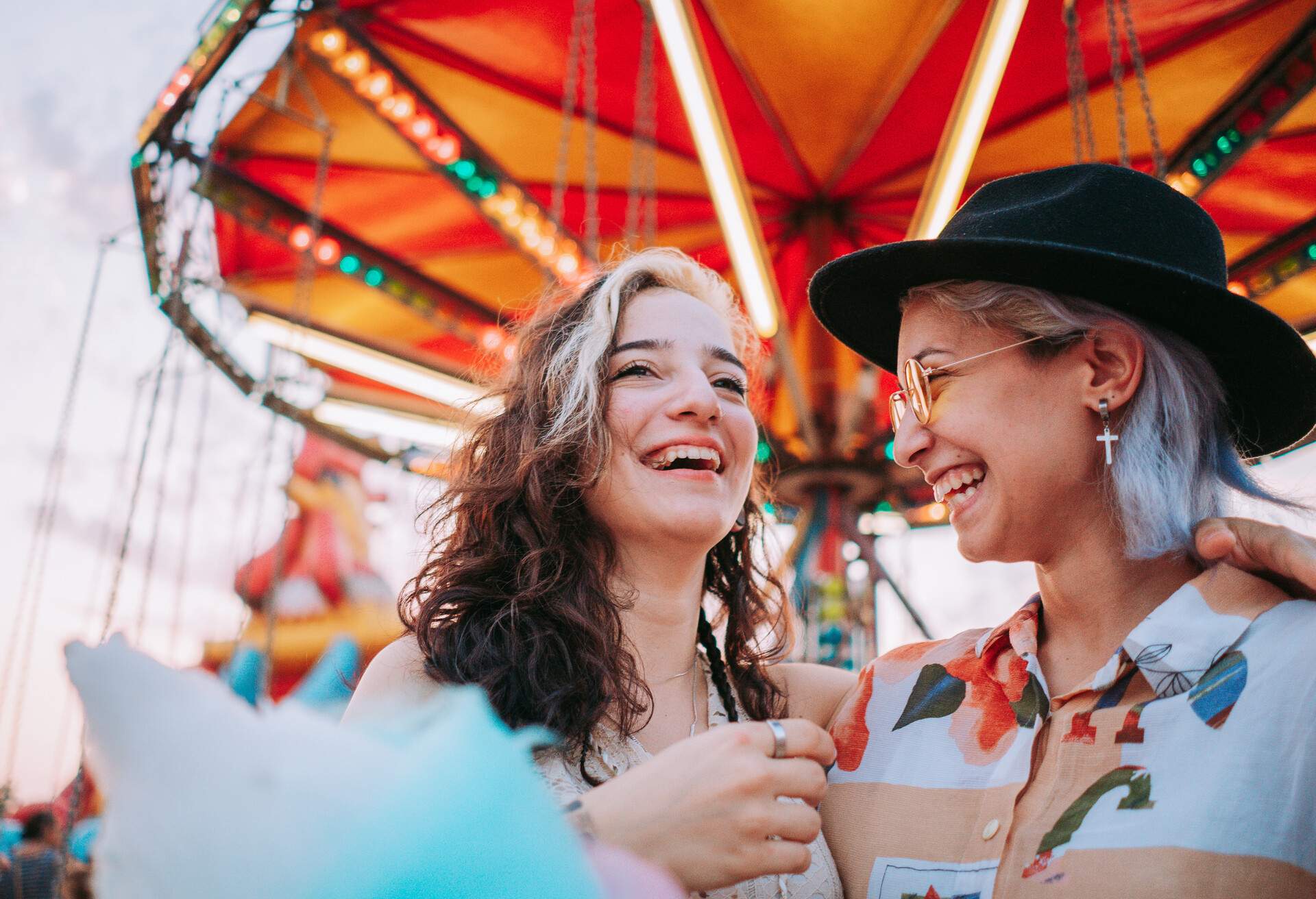 Happy girlfriends are make fun together in fun fair