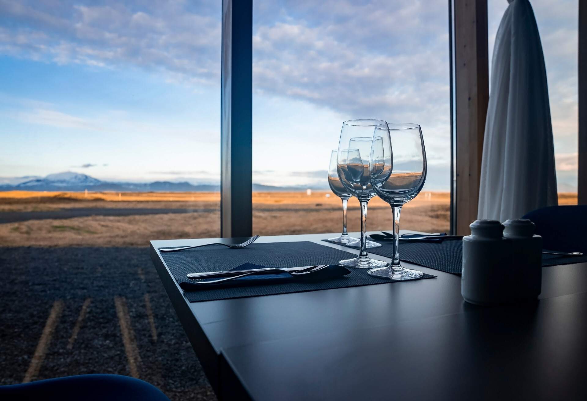 Close-up of wine in glasses on table. Alcoholic beverages are served against window with view of cloudy sky. Concept of catering in restaurant at luxurious resort.