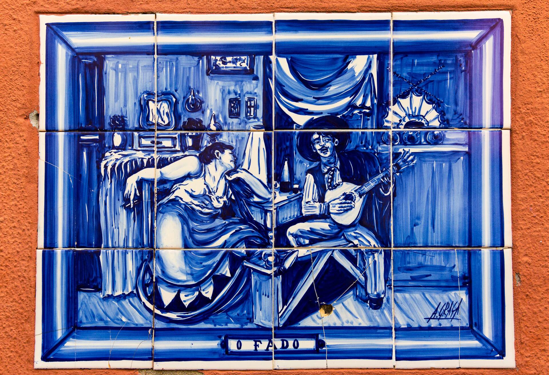 An exterior wall with a fado artwork made of blue and white ceramic tiles.