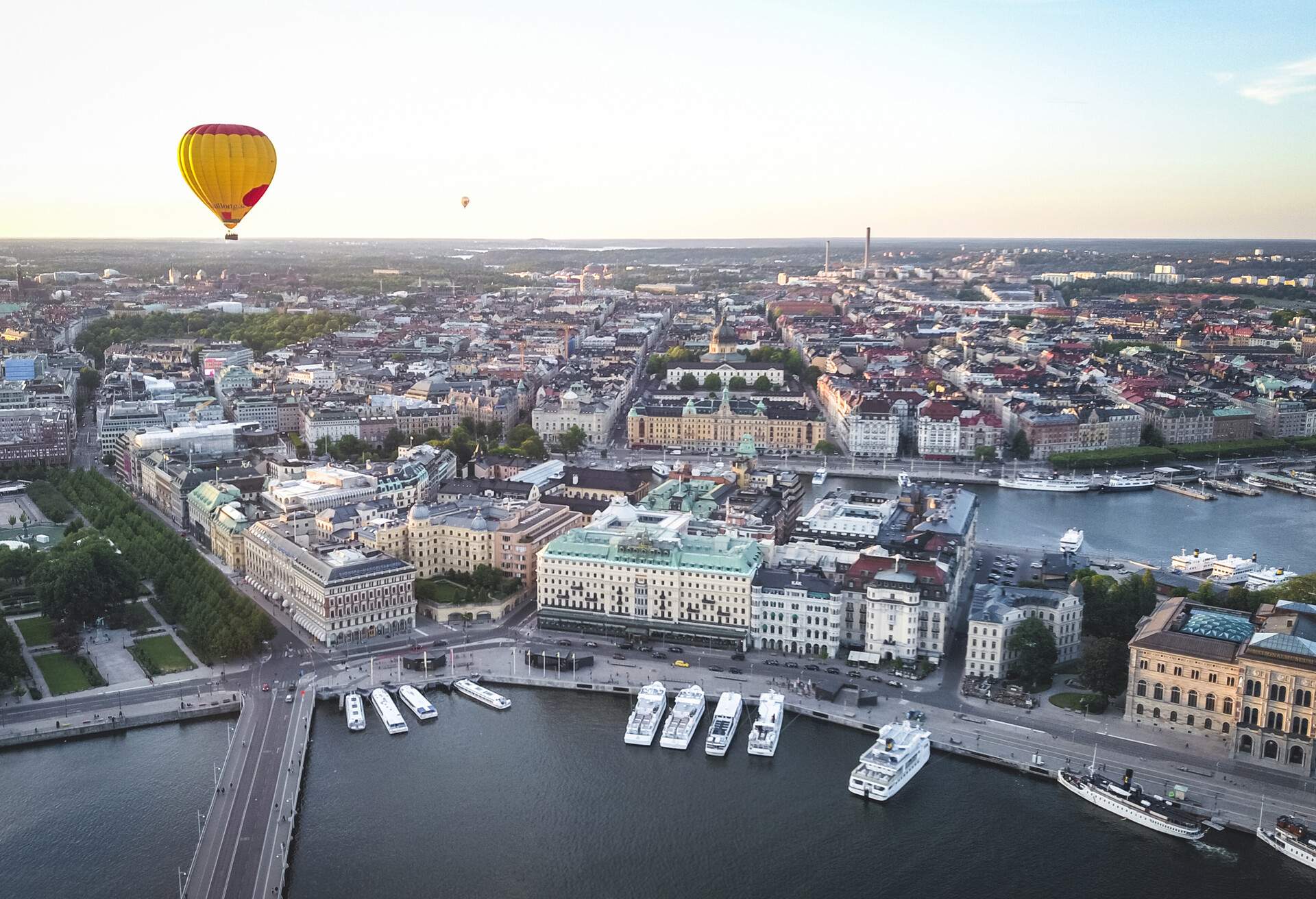 Aerial drone view of Stockholm city skyline of Kungstradgarden, Grand Hotel and National museum at sunet, with hot air balloon floating above Norrmalm of Stockholm, capital city of Sweden.