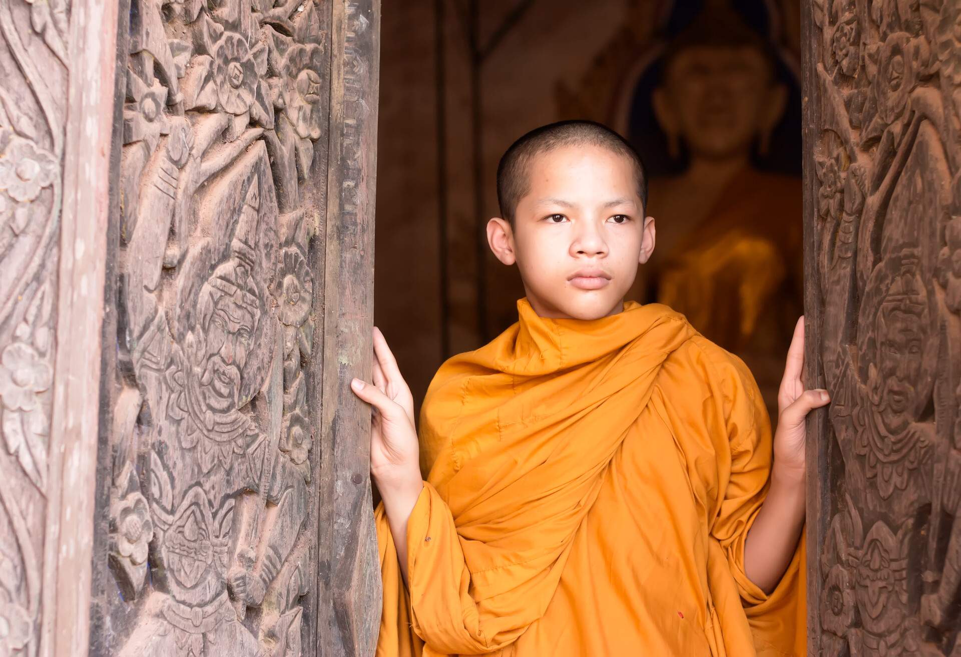 Novices monk standing at door in temple .Luang Prabang