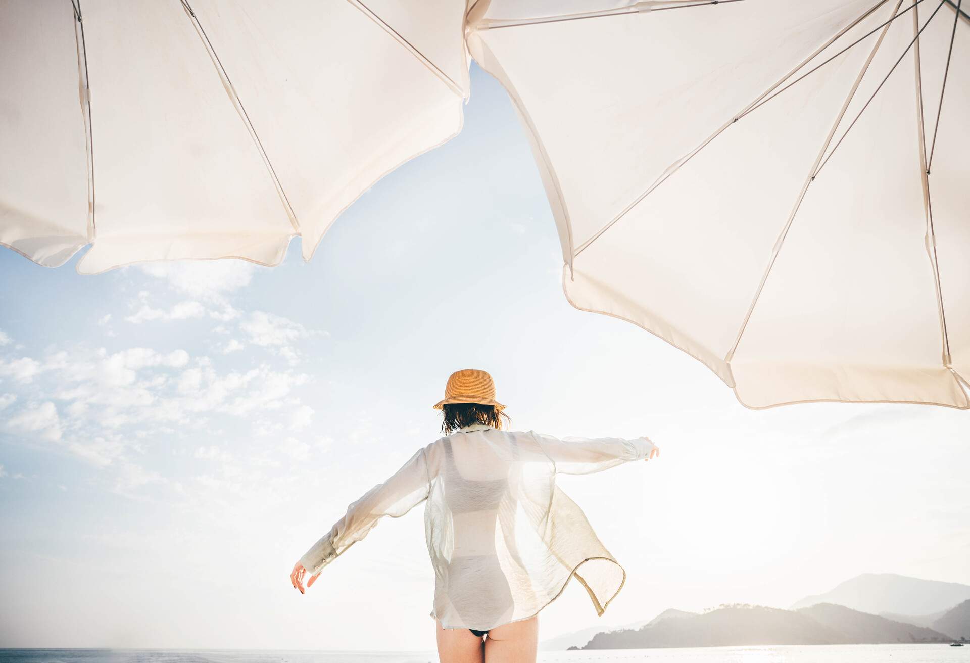 Back view of woman walking on beach.