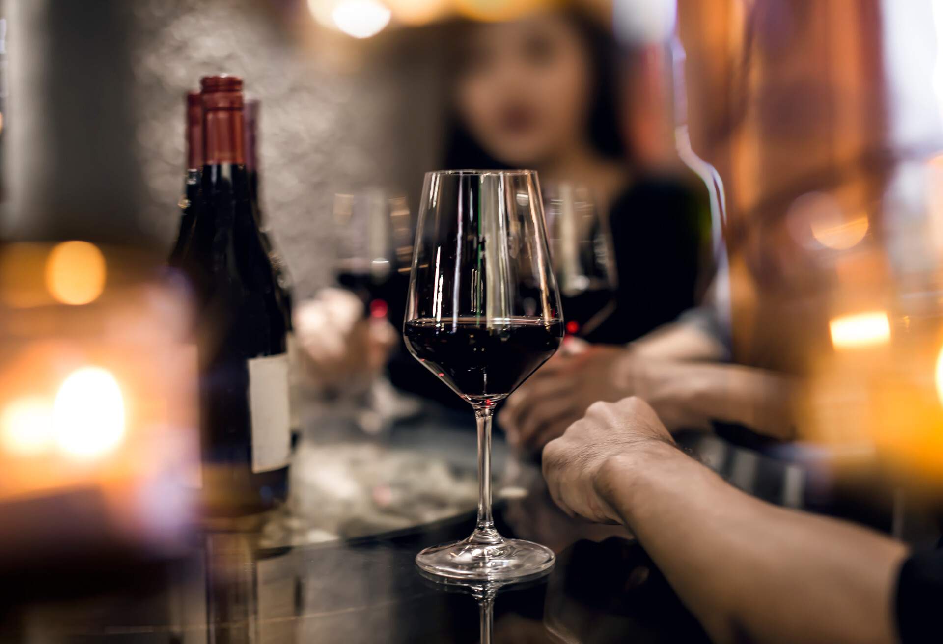 Red wine glass with friends, out of focus; Shutterstock ID 1280665558; Purpose: NYC&co Restaurant week; Brand (KAYAK, Momondo, Any): KAYAK