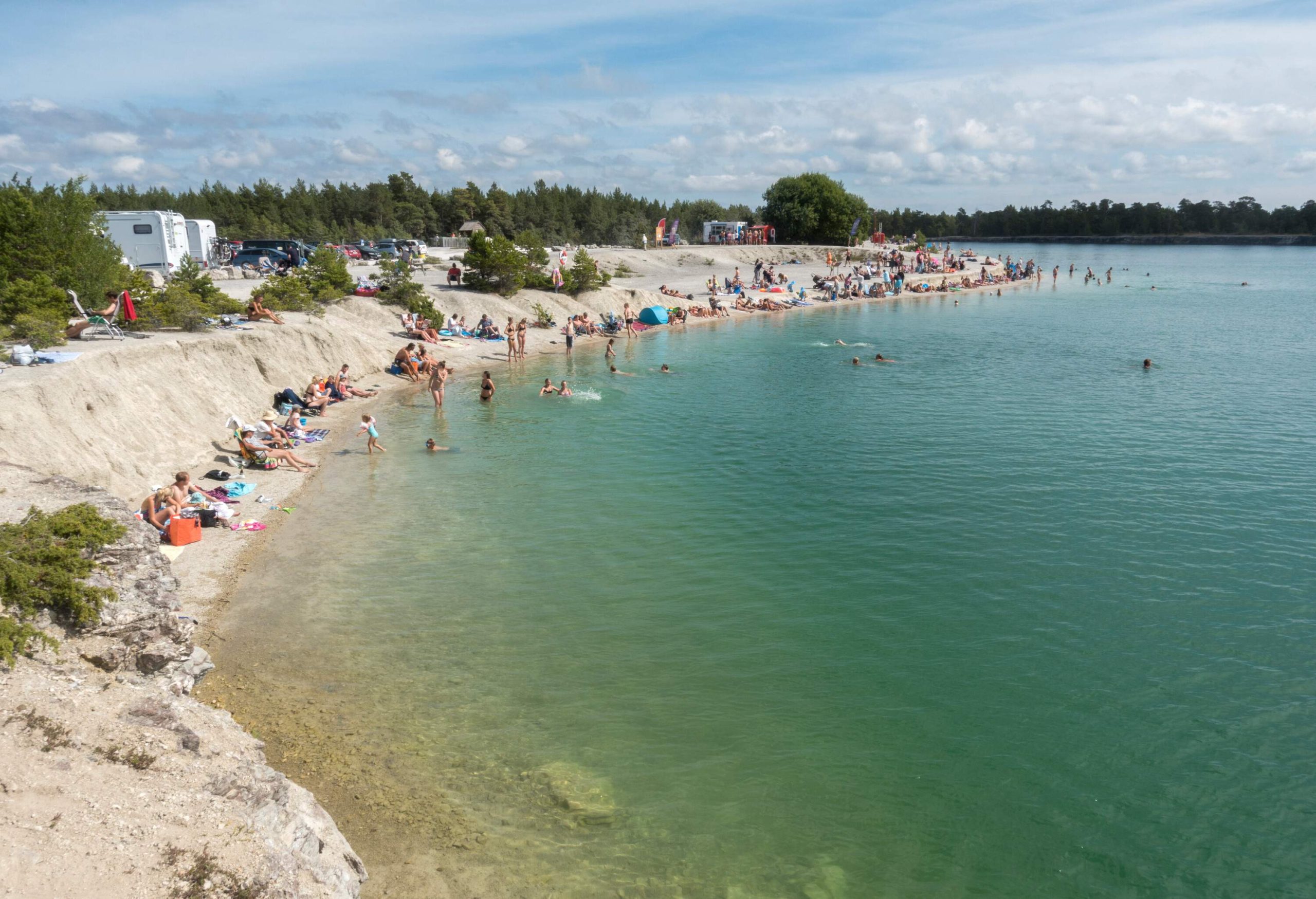 People enjoying a day out on the beach camping and relaxing on the shore.