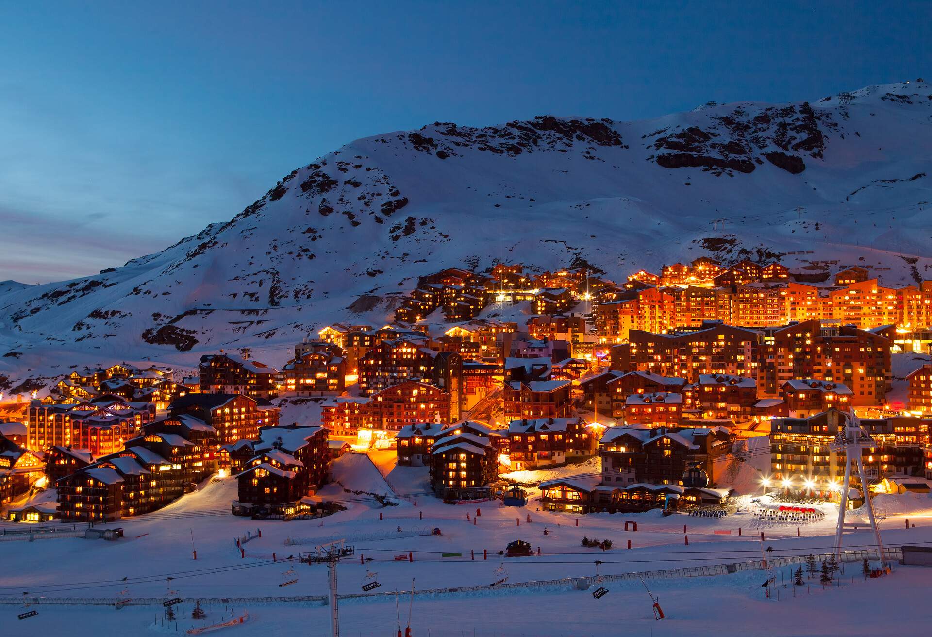 Mountain chalets along the Alps boasting with warm lights in the night.