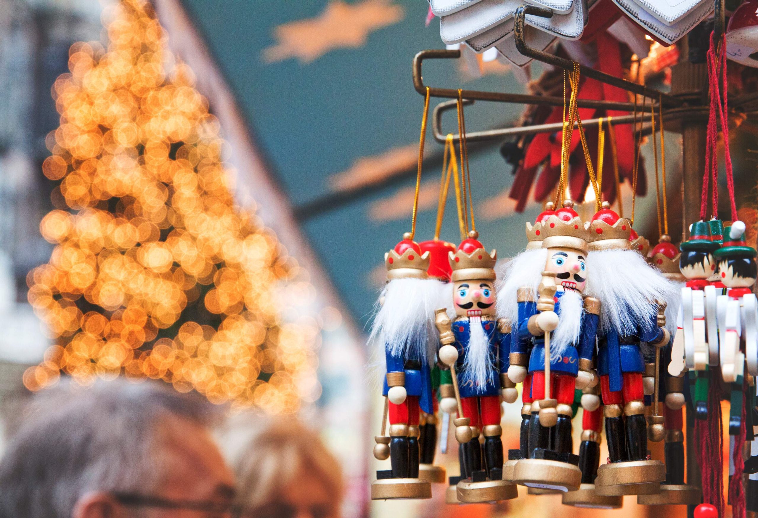 Toy souvenirs of a white-haired nutcrackers holding a baton on display.