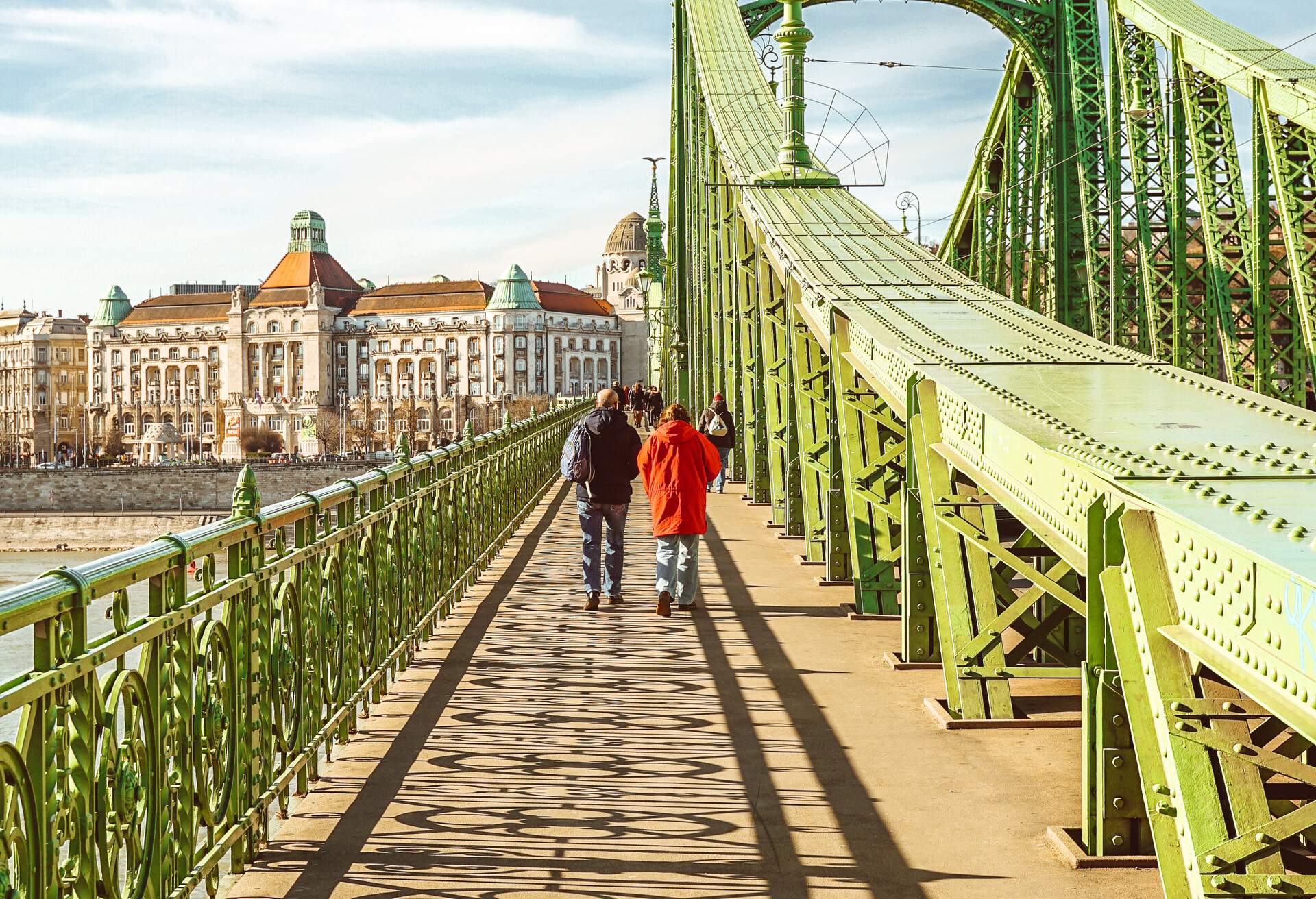 A pedestrian bridge with people walking across it.