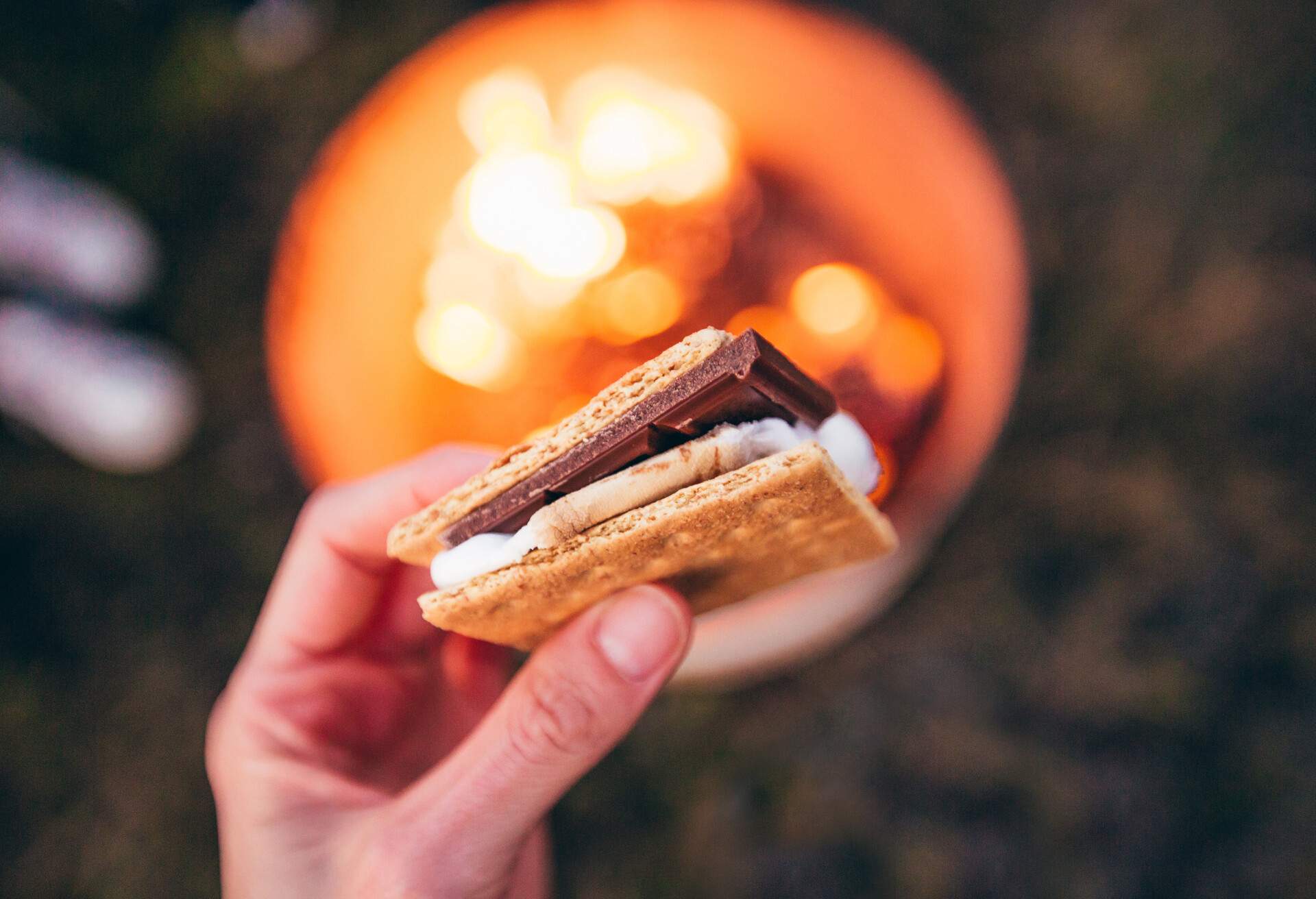 Holding s'more over a campfire.