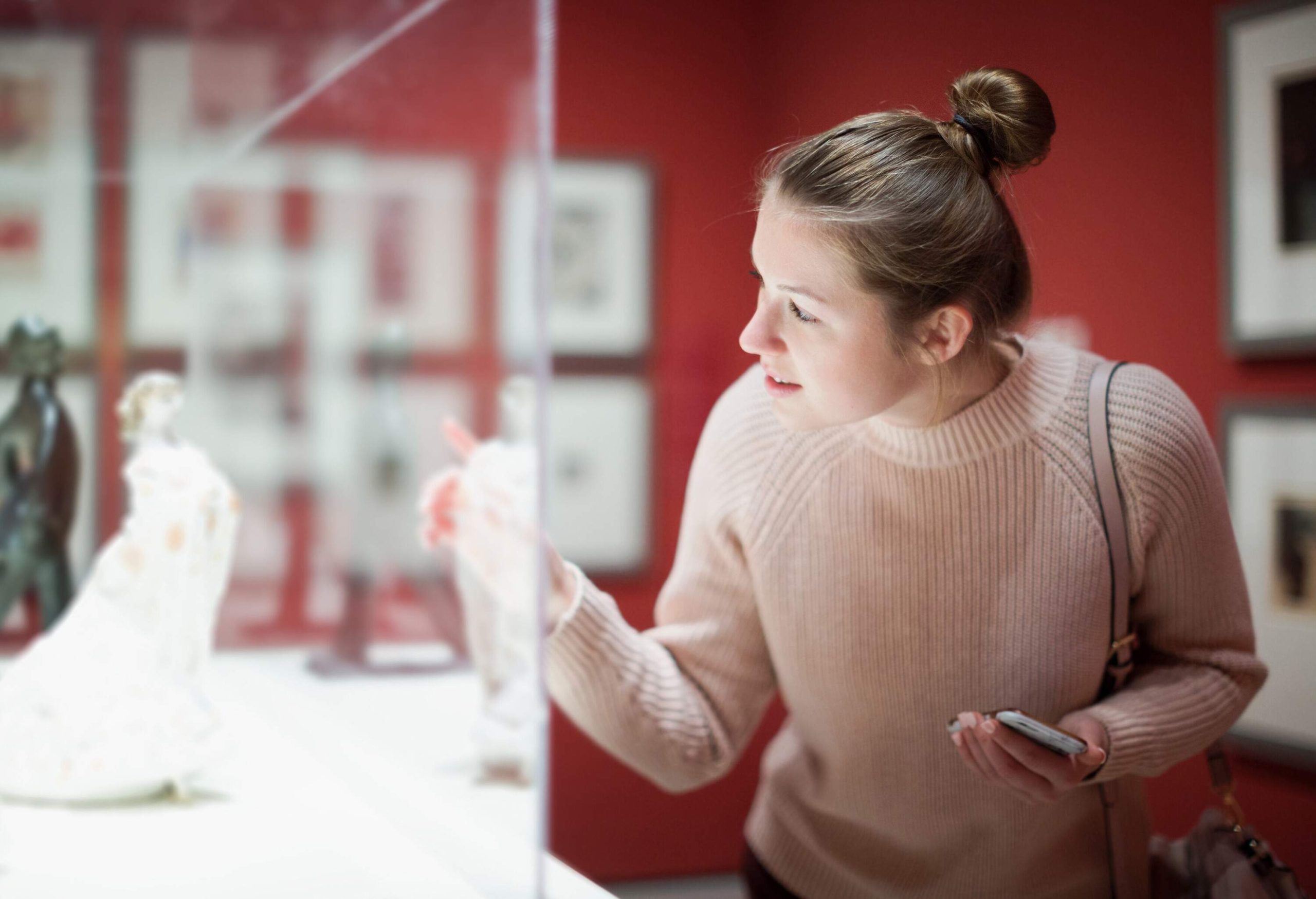 A young lady is amazed by the display in the museum.