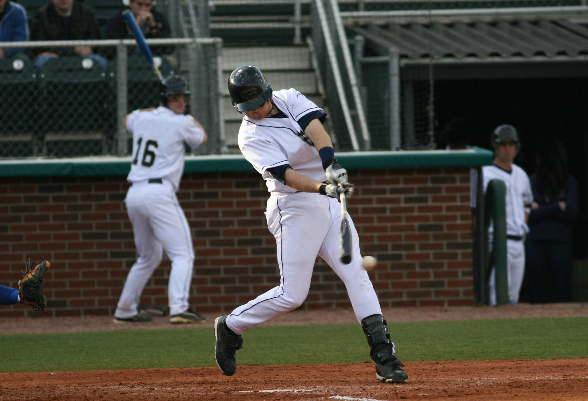 A baseball player hitting a ball with a bat in the field.