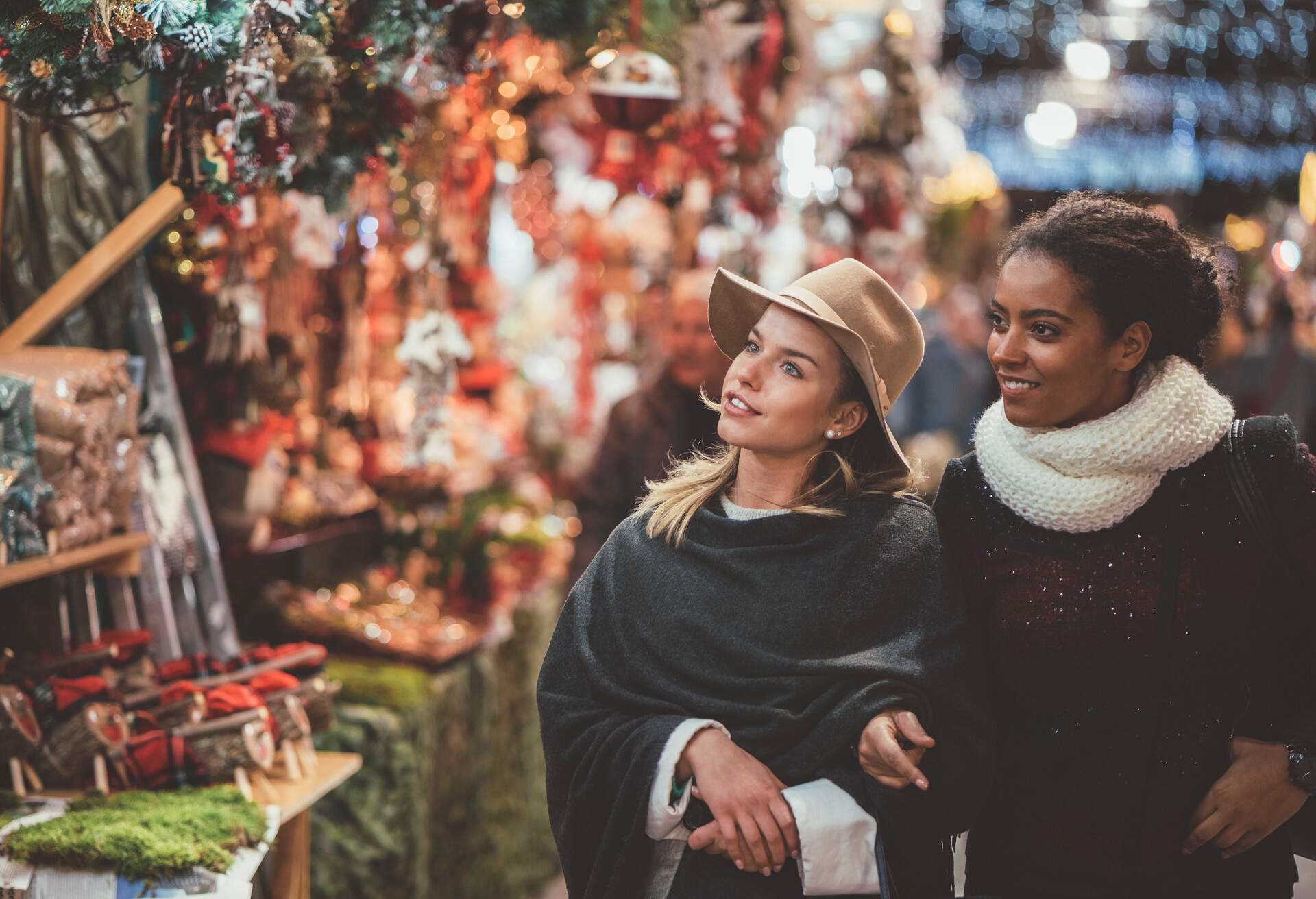 Two women looking at the Christmas ornaments displayed outside the stalls.