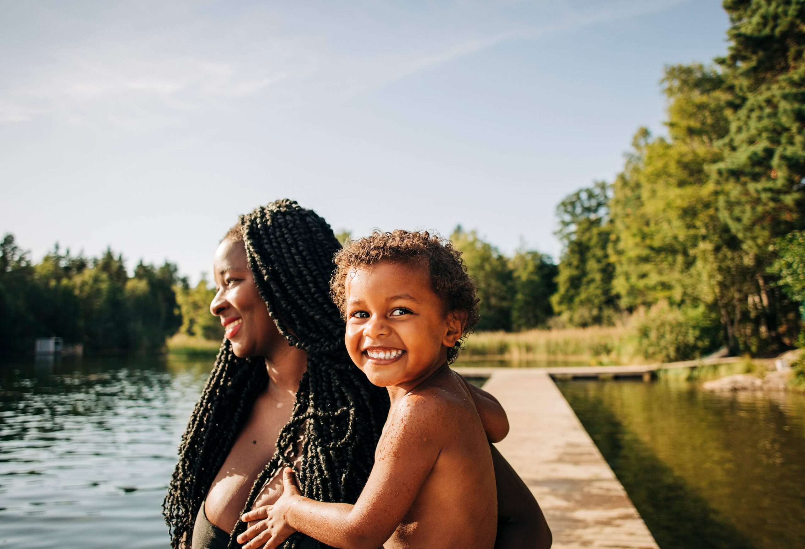 PORTRAIT OF MOTHER AND CHILD BY A LAKE ON A SUMMER DAY